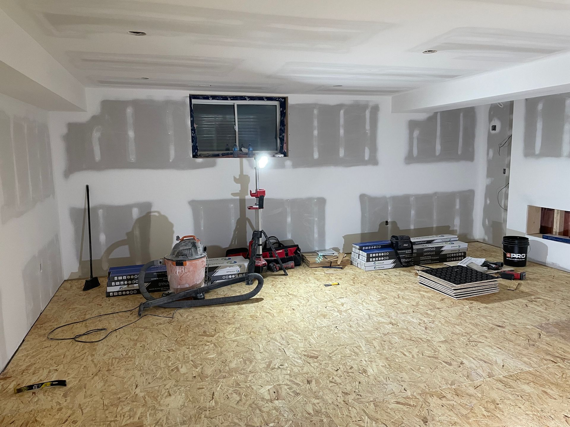 A room with a wooden floor and a vacuum cleaner in it.