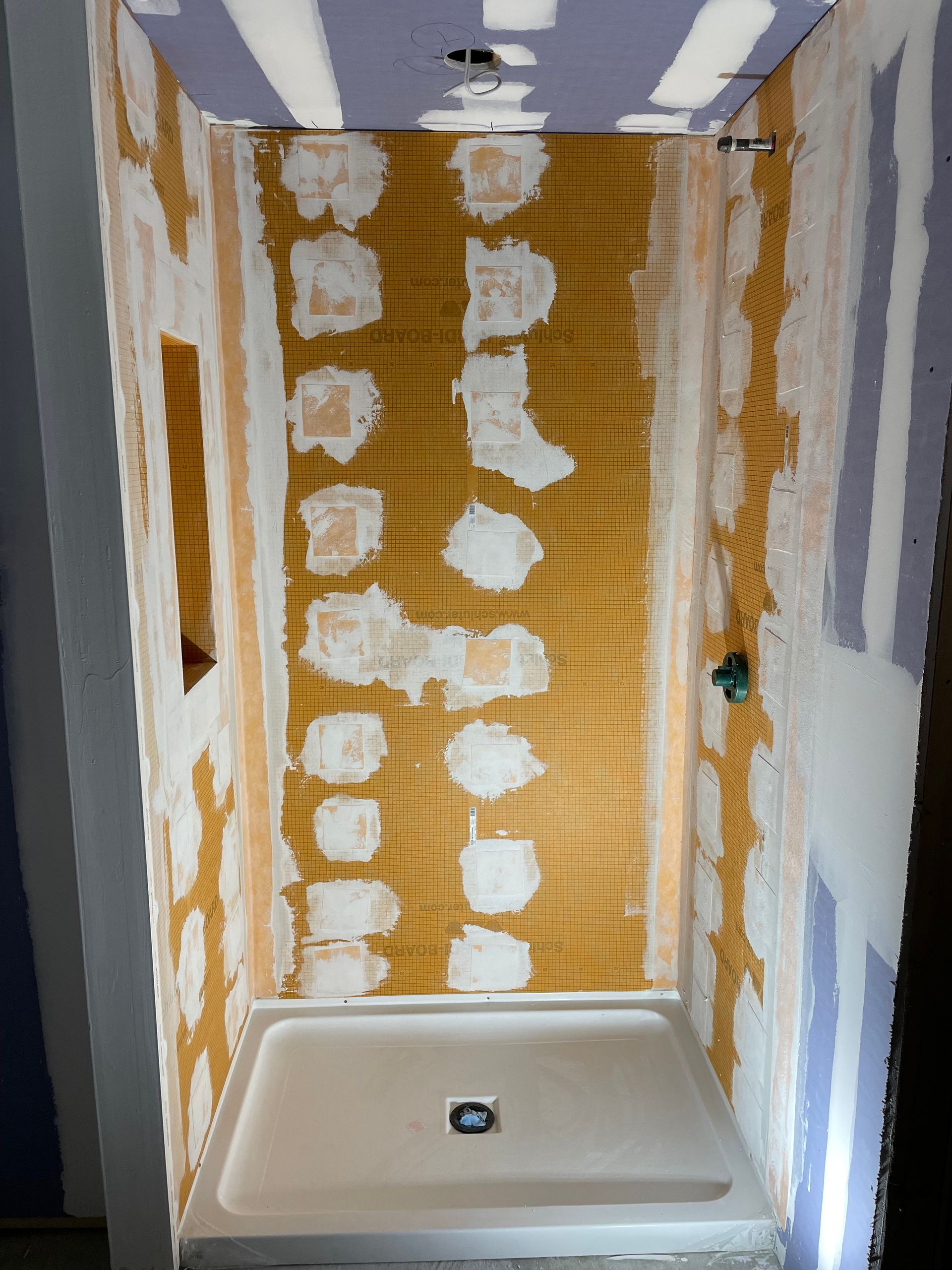 A shower stall is being built in a bathroom.