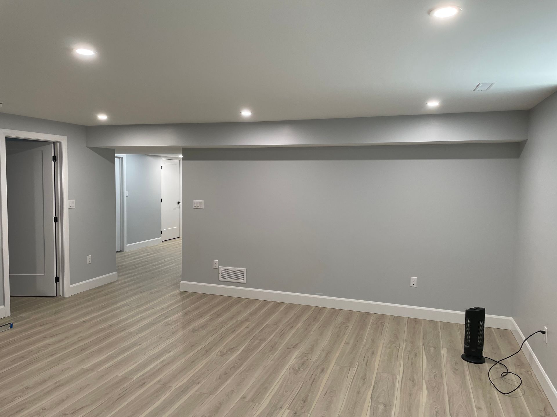 There is a fan in the middle of the room in the basement.