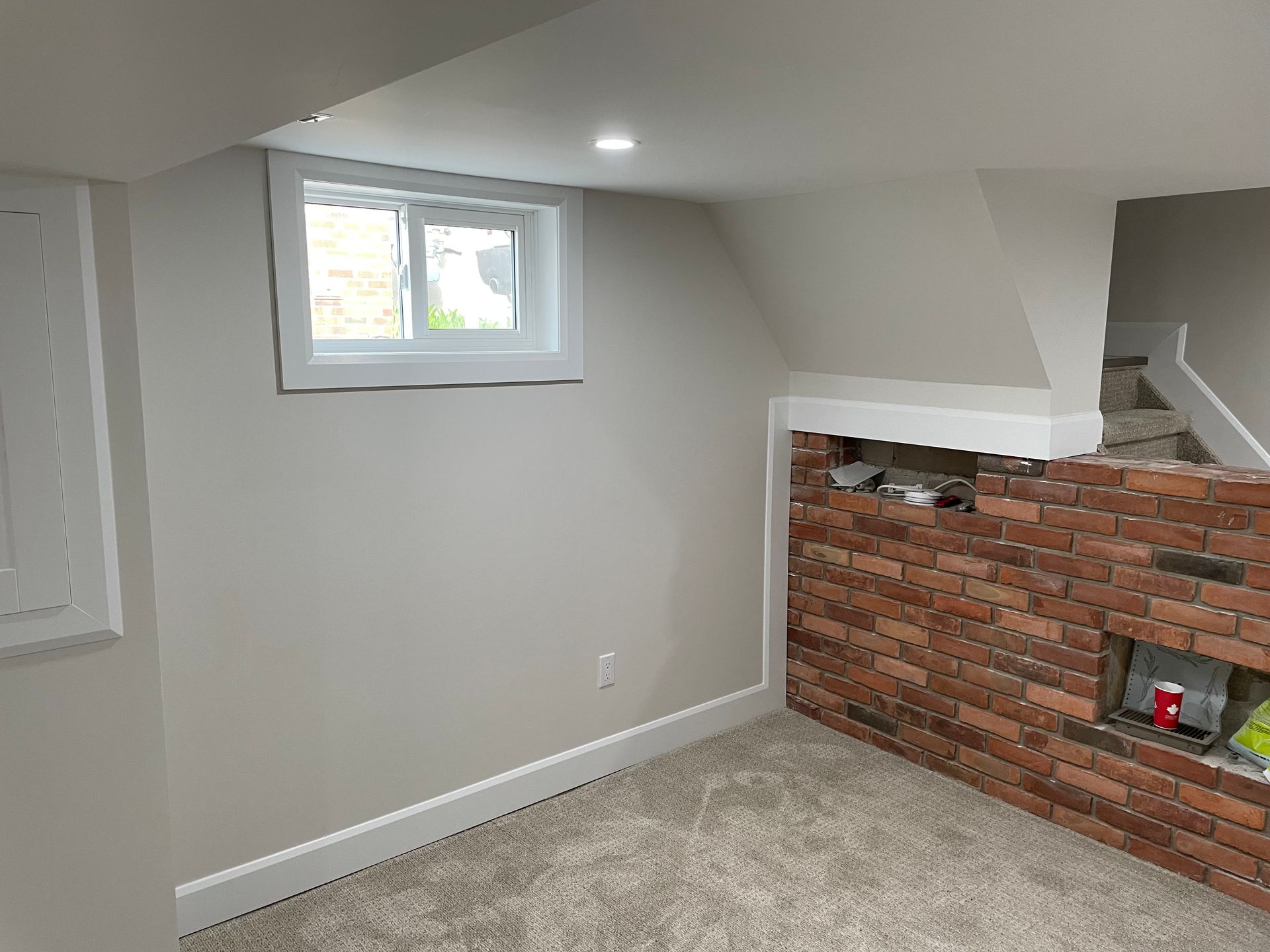 A room with a brick wall and a window.