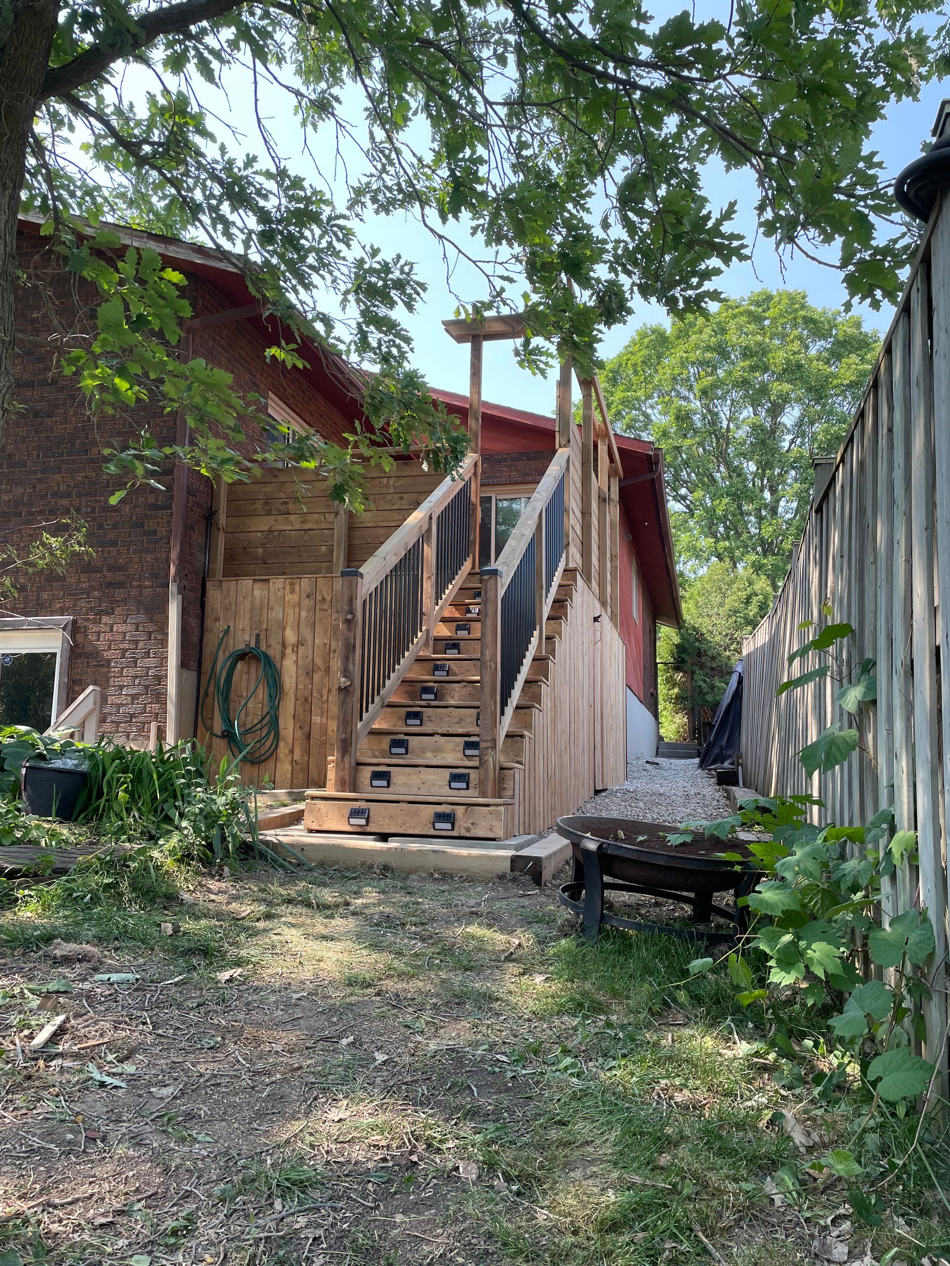A wooden deck with stairs leading up to a house.