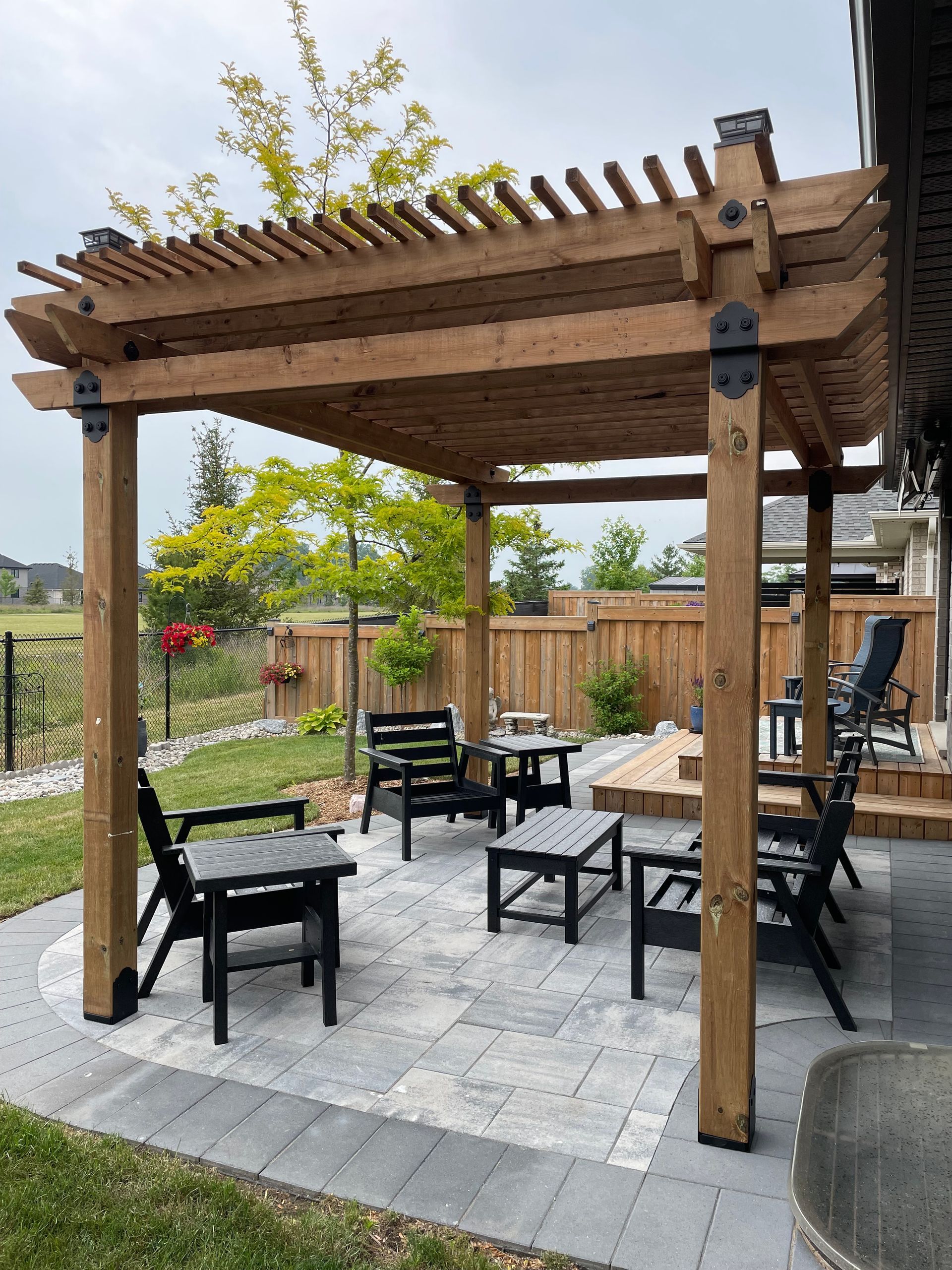 A wooden pergola with chairs and tables underneath it