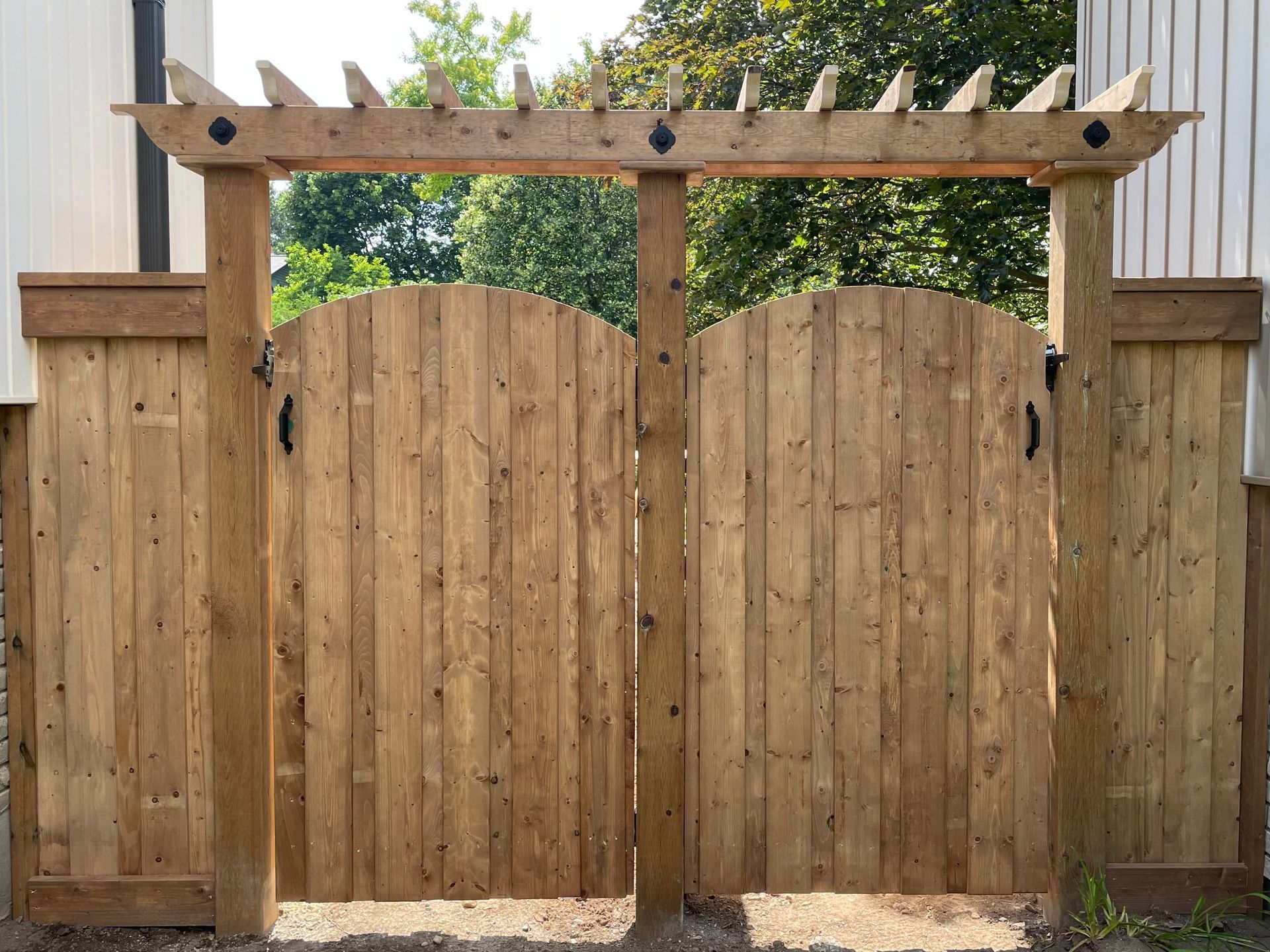 A wooden gate with a pergola attached to it