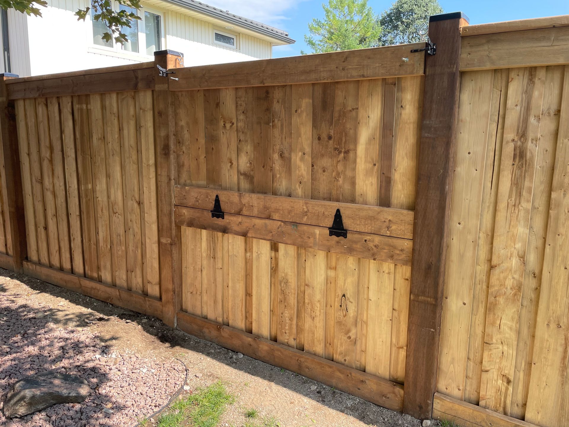 A wooden fence is sitting next to a house.