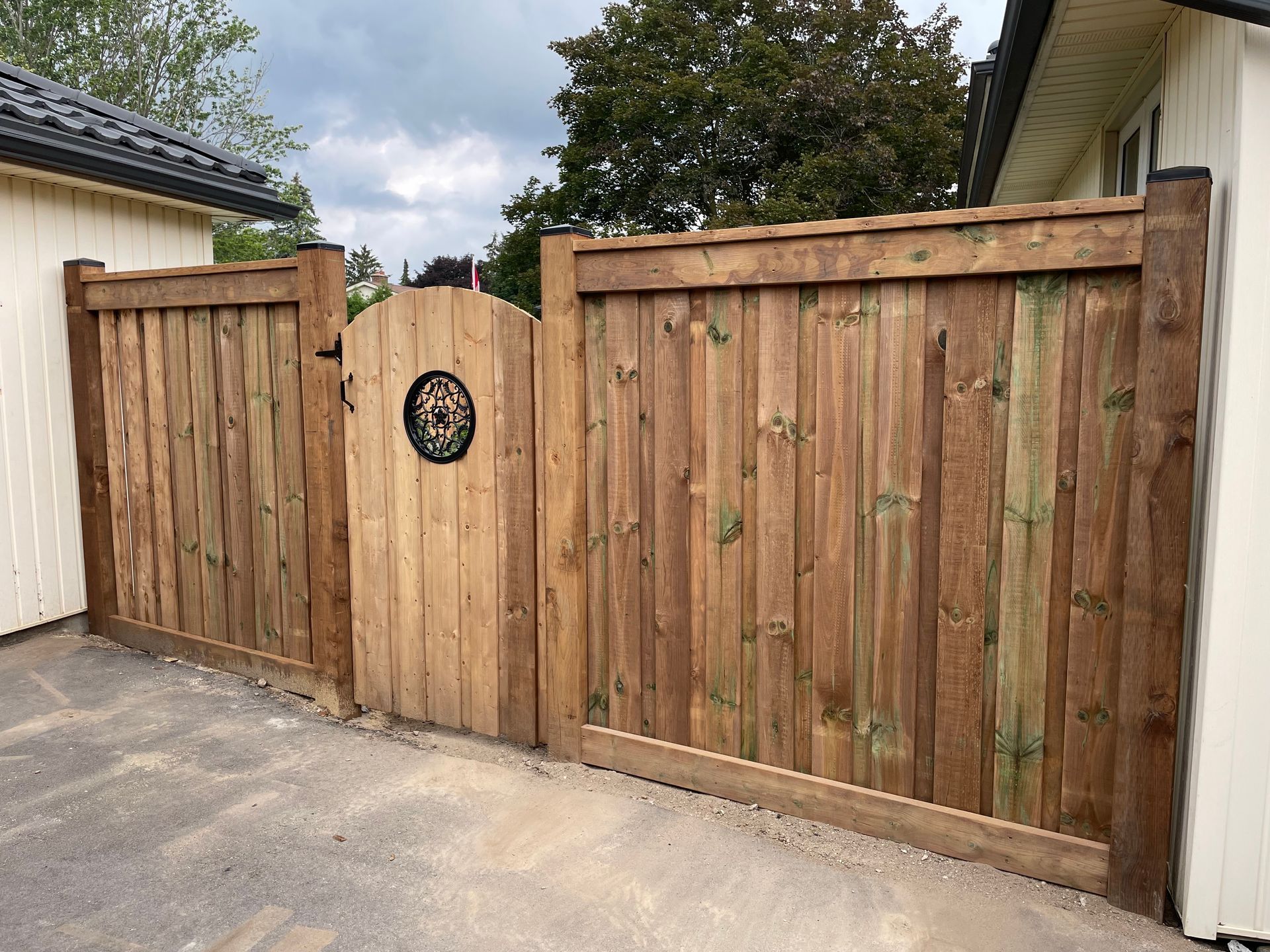 A wooden fence with a gate in front of a house.
