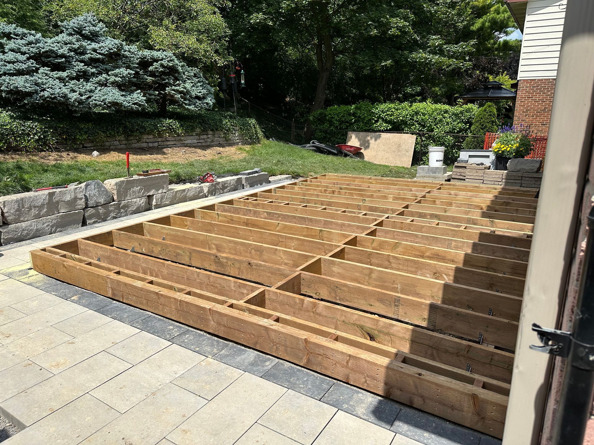 A wooden deck is being built in a backyard.