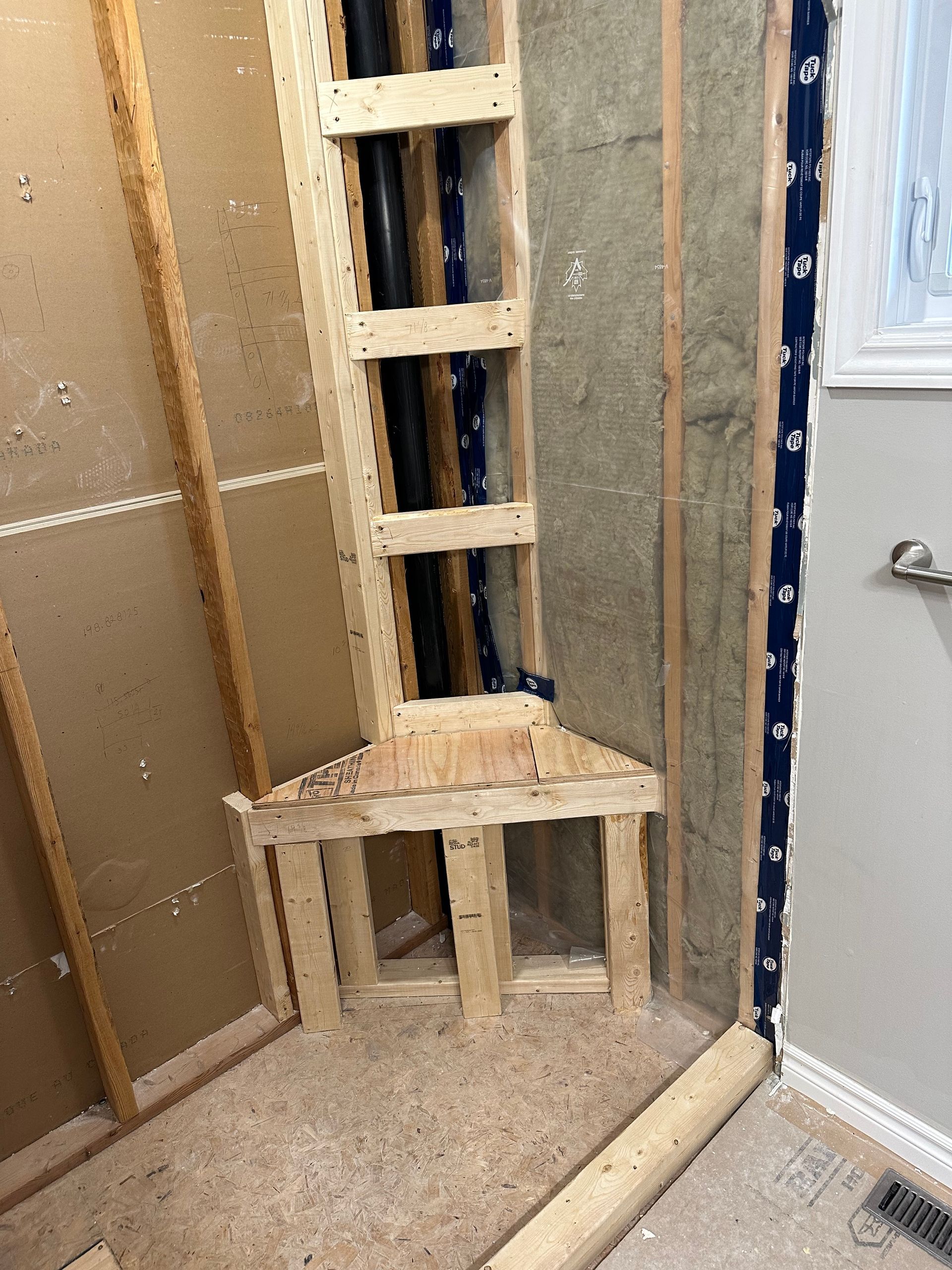 A wooden frame is being built in a bathroom.