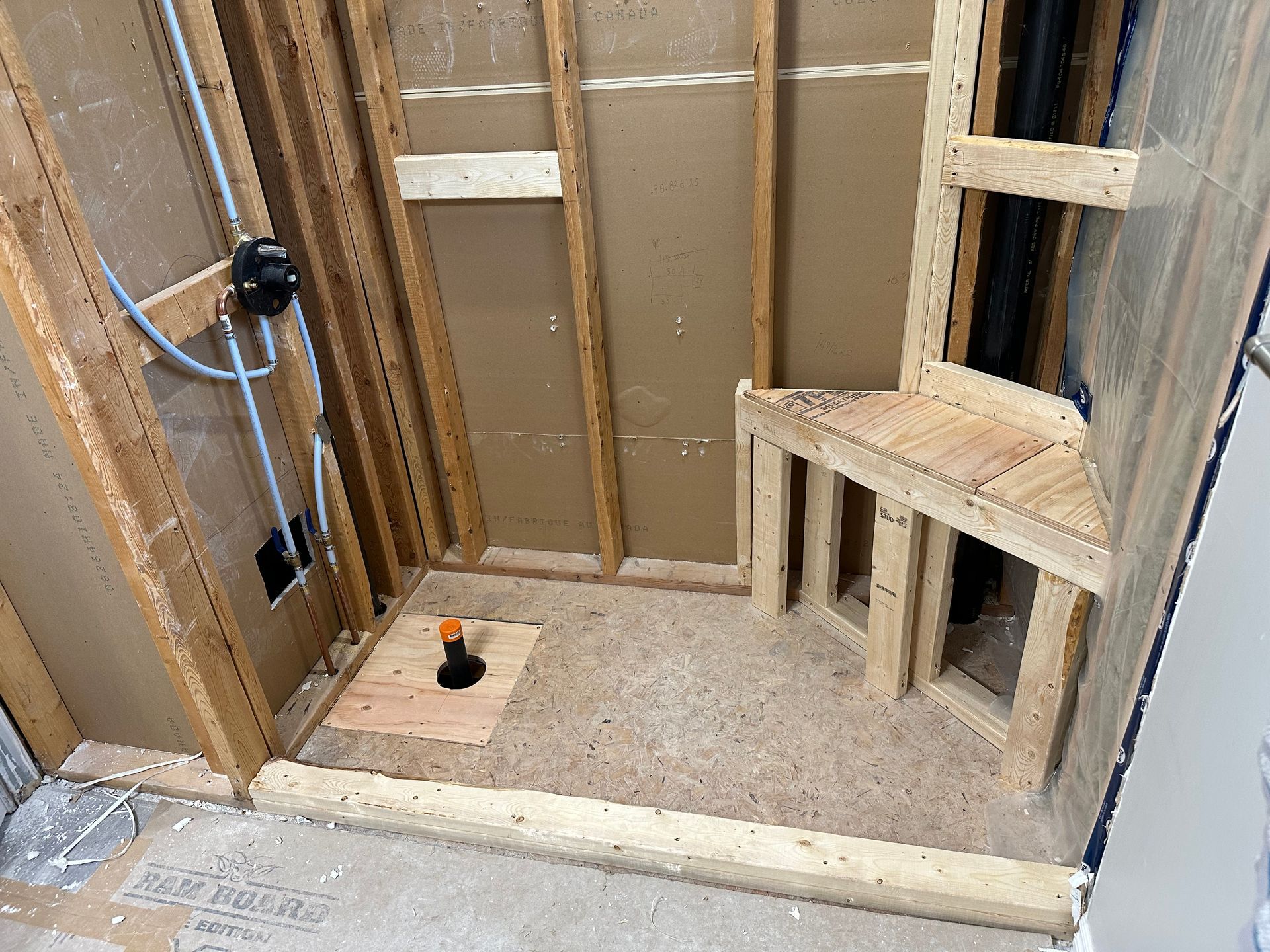 A bathroom under construction with wooden walls and a wooden bench.