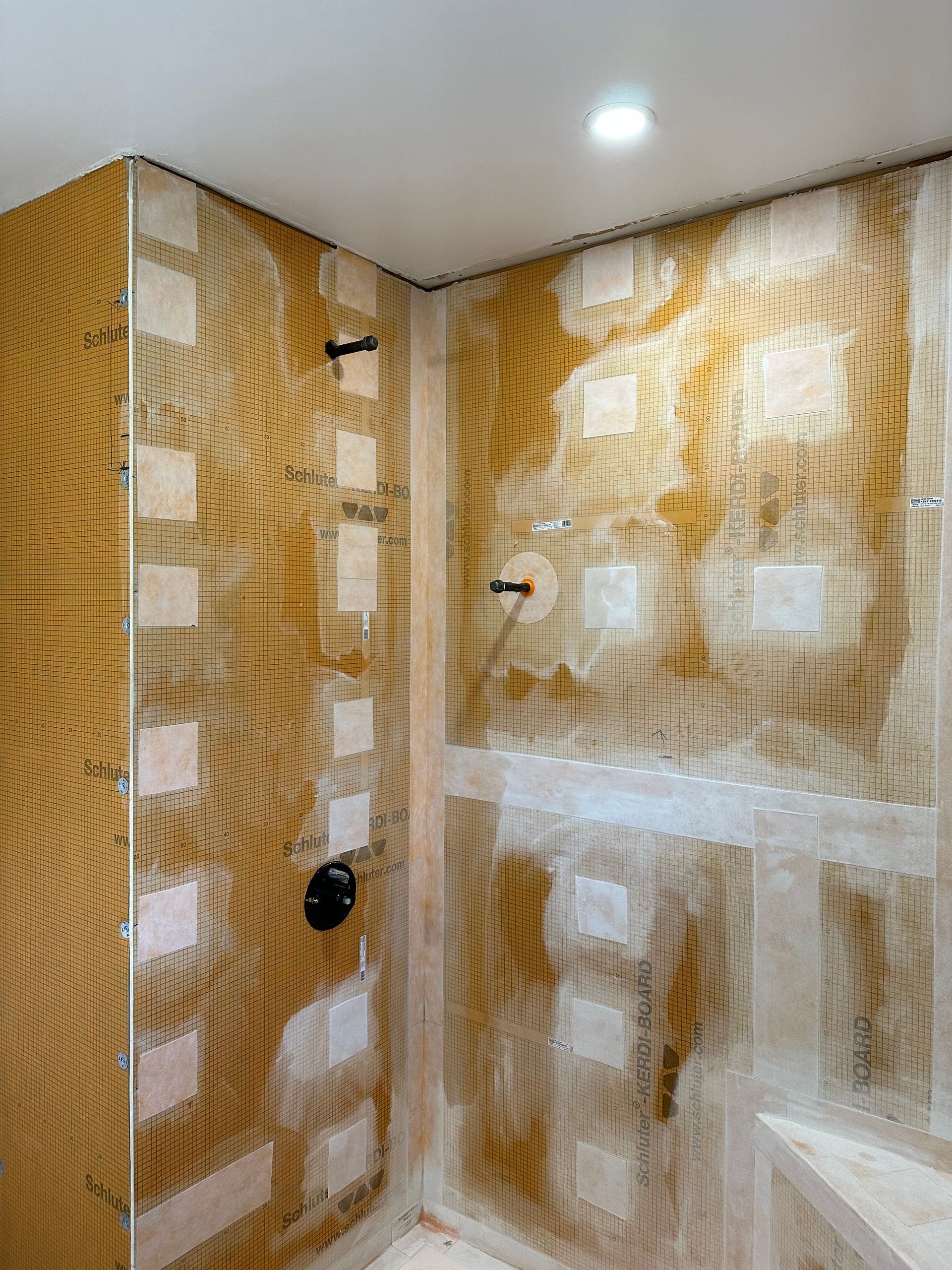 A bathroom with a shower stall being remodeled.