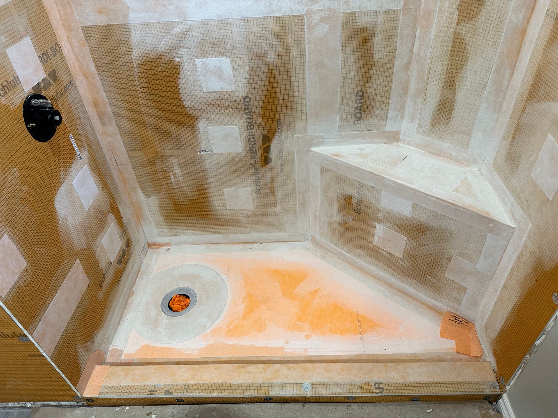 A shower stall is being built in a bathroom.