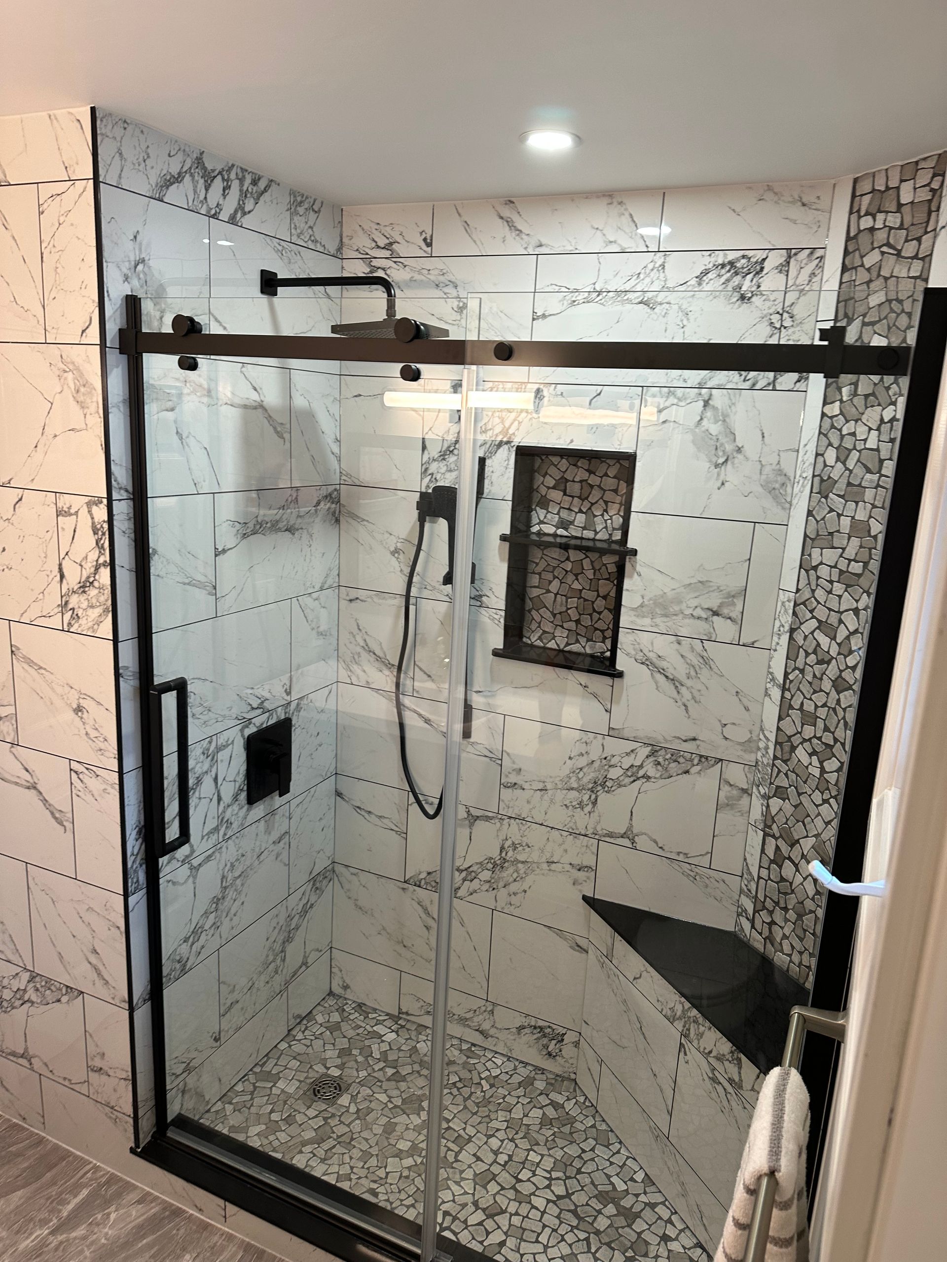 A bathroom with a sliding glass shower door and a shower head.