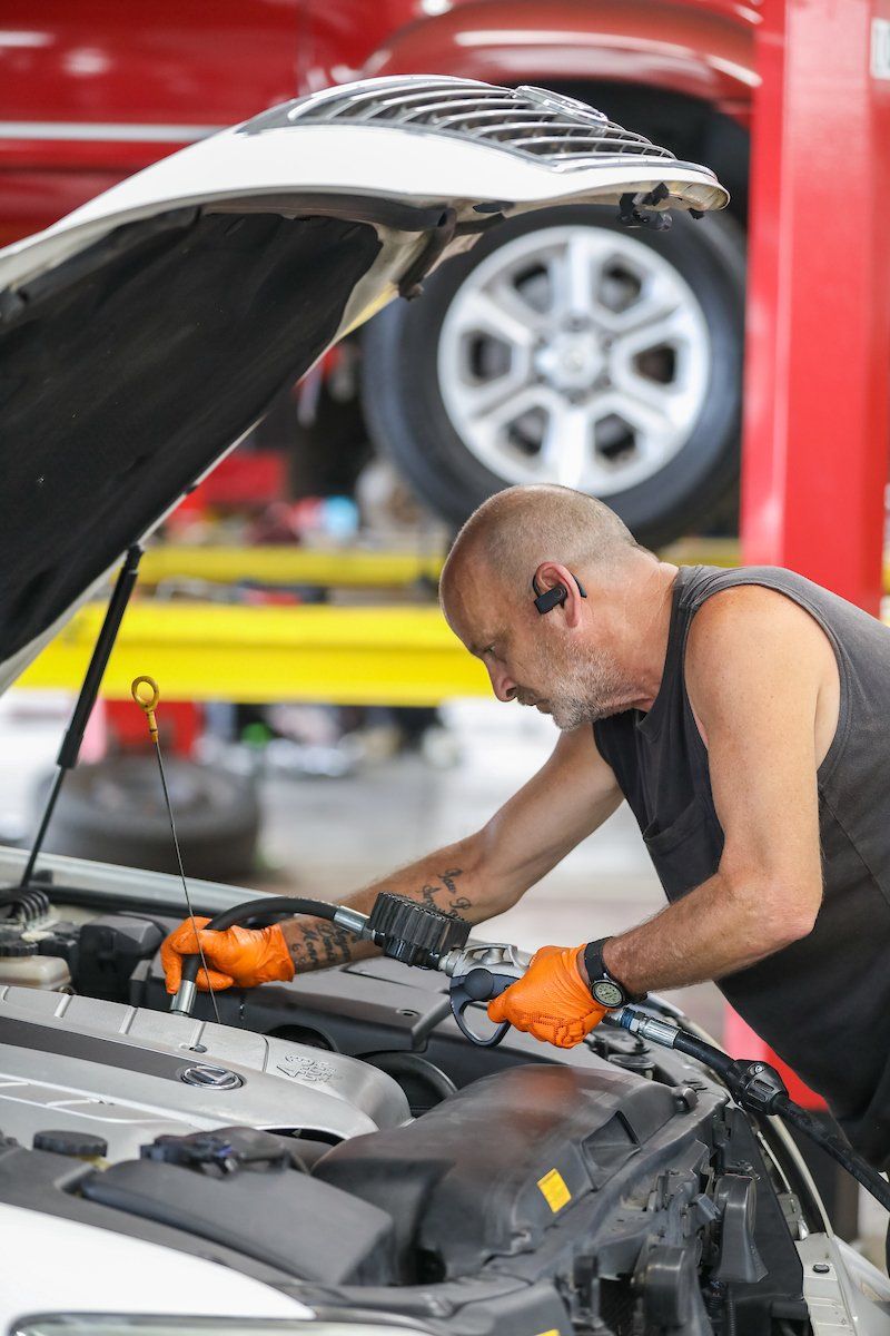 A man is working on the engine of a car in a garage.