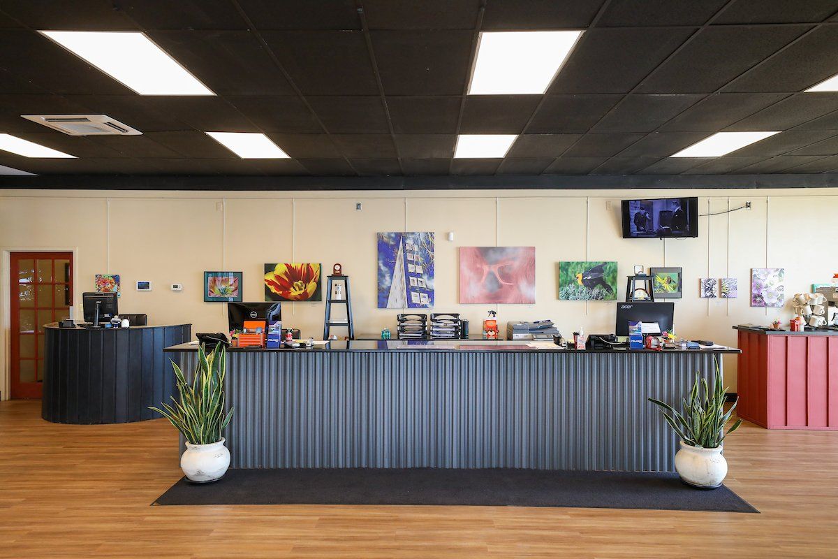 A large room with a reception desk and a lot of paintings on the wall.