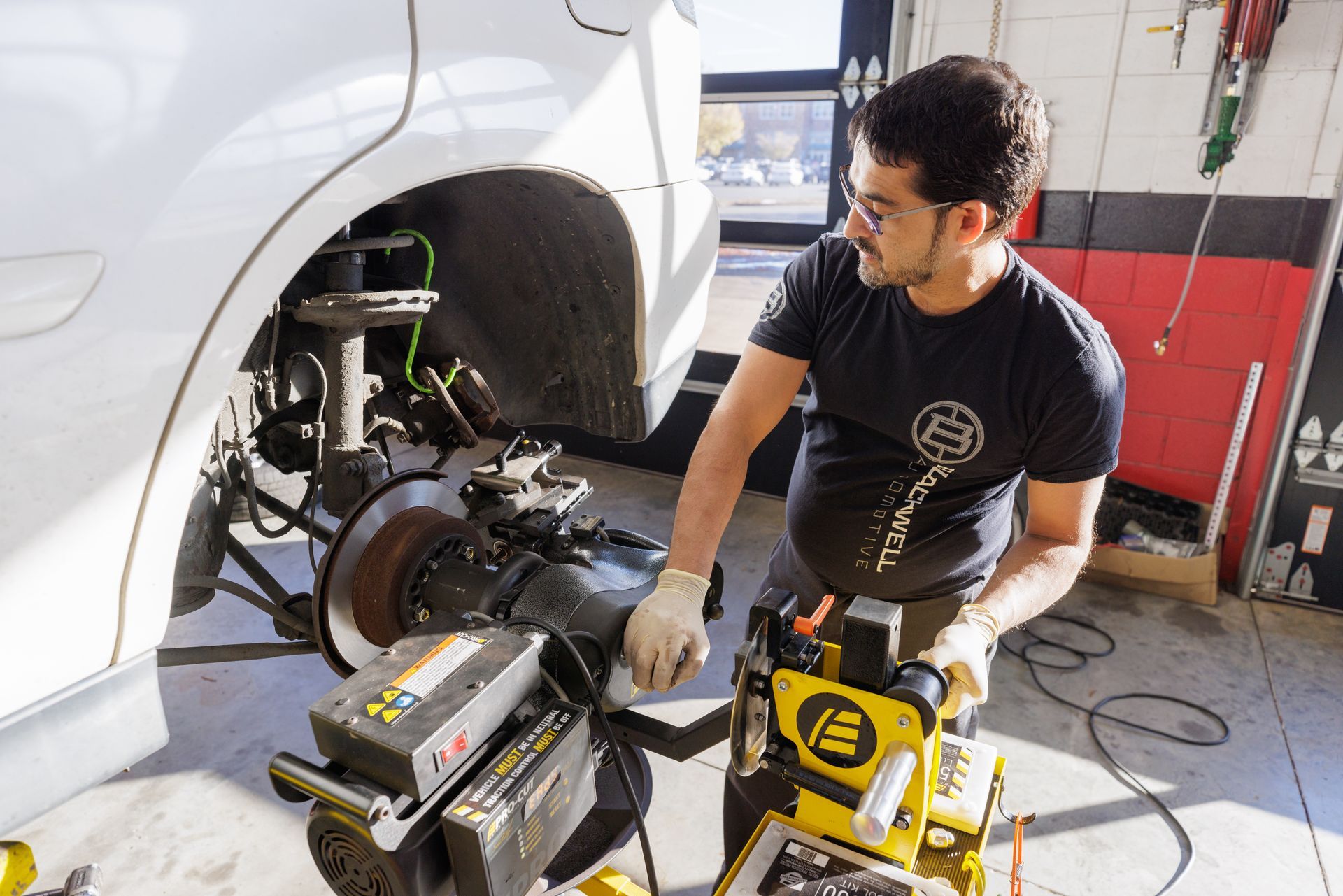 A man is working on a car in a garage.