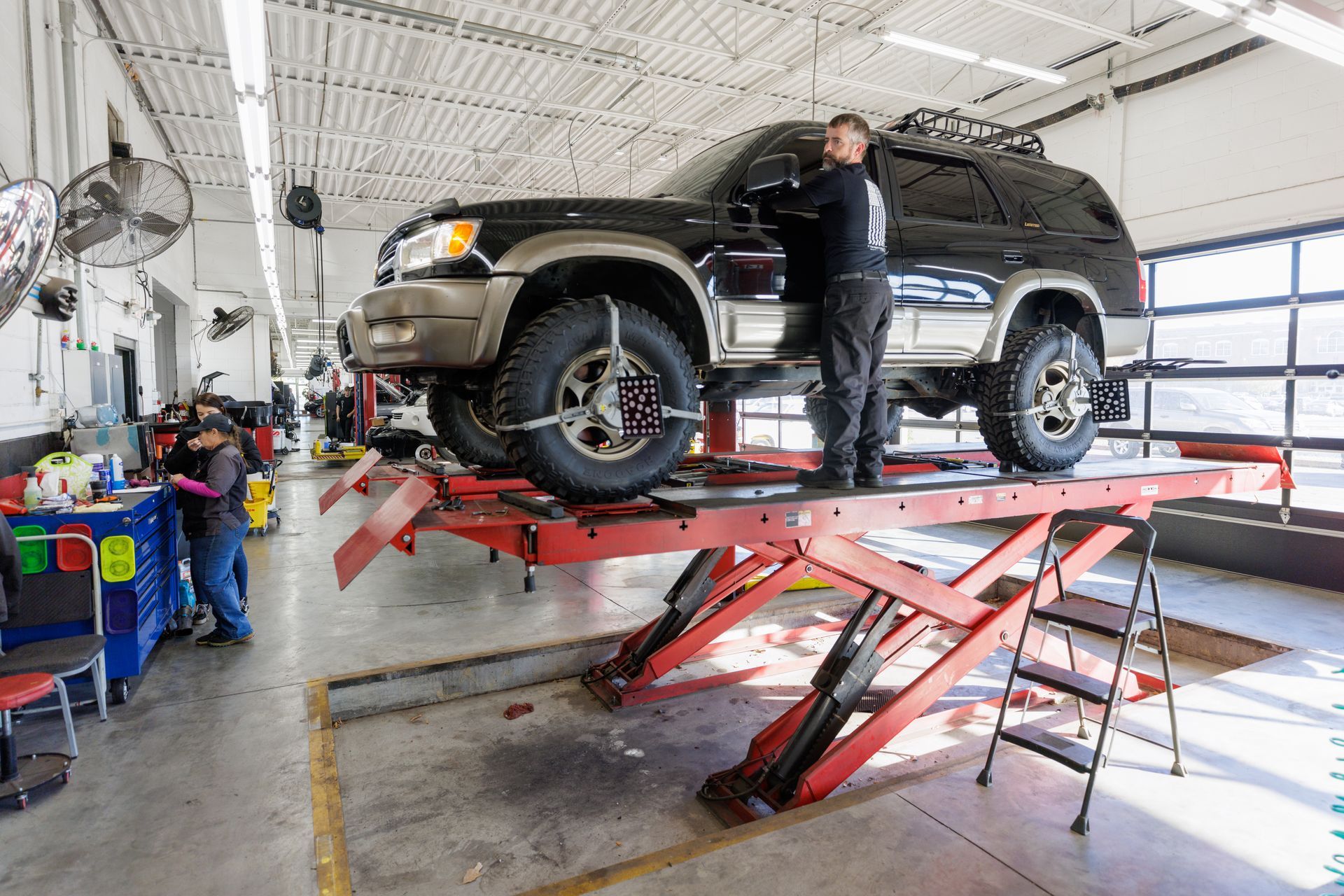 A car is sitting on a lift in a garage.