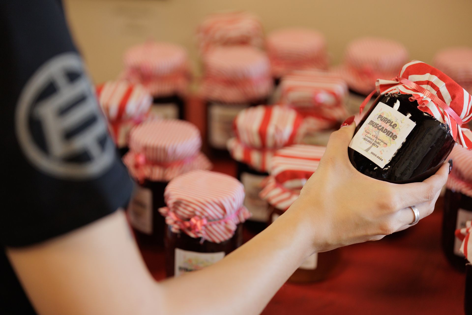 A person is holding a jar with a label that says ' strawberry jam ' on it