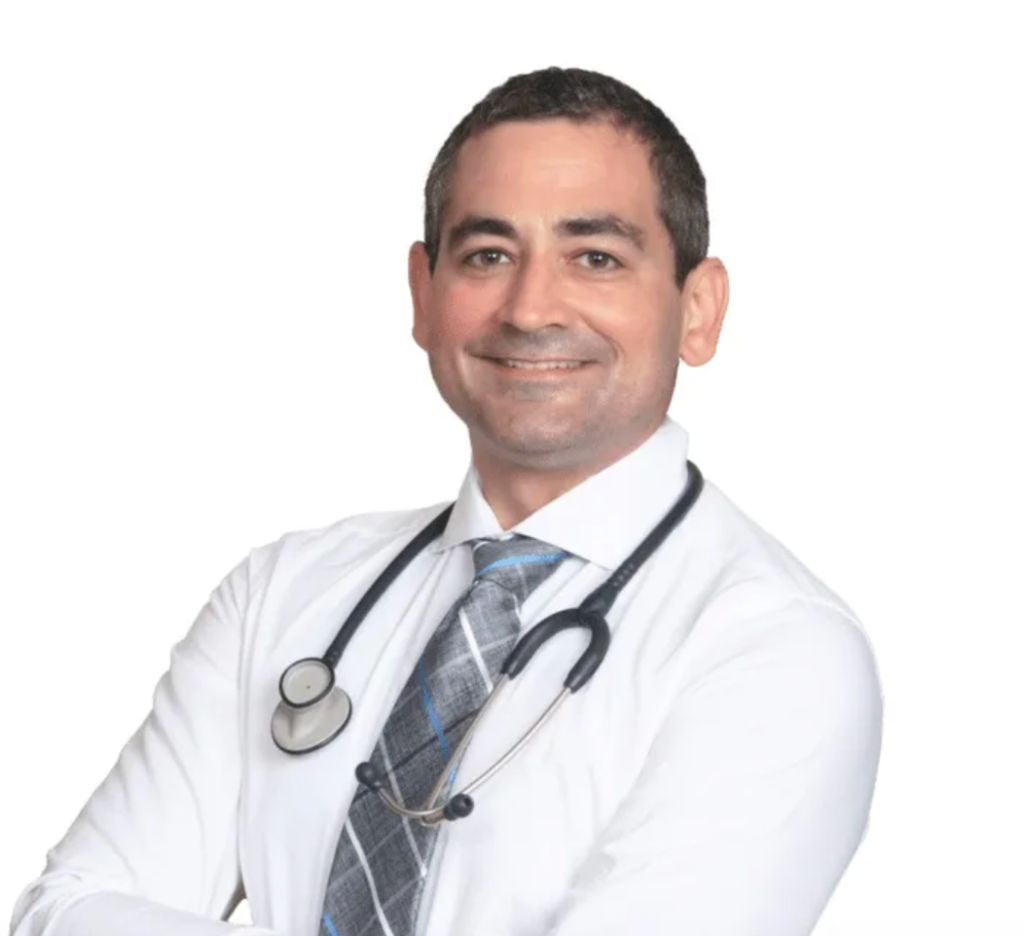 Smiling doctor in a white coat with a stethoscope, standing against a white background