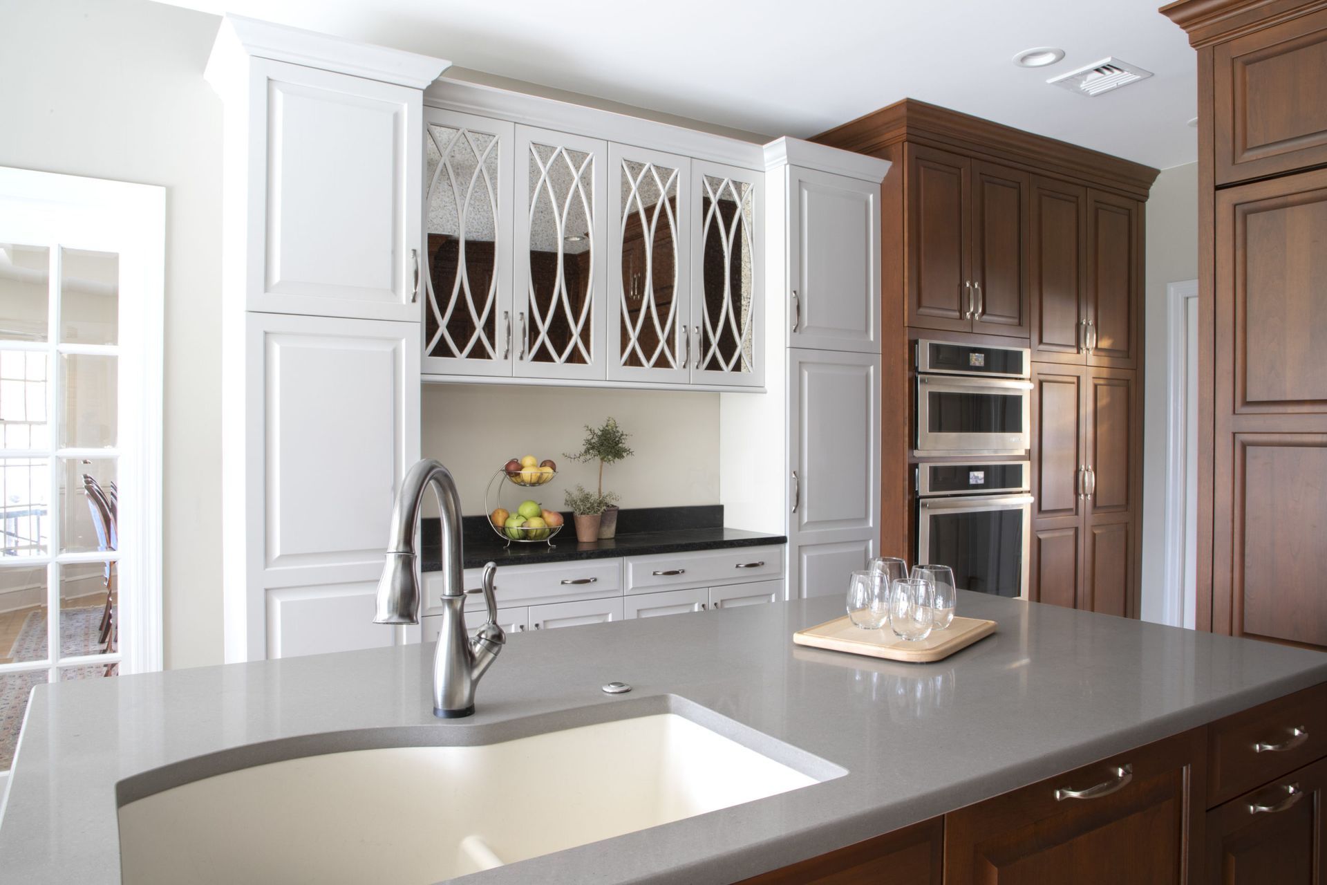 A kitchen with a sink and a cutting board on the counter.