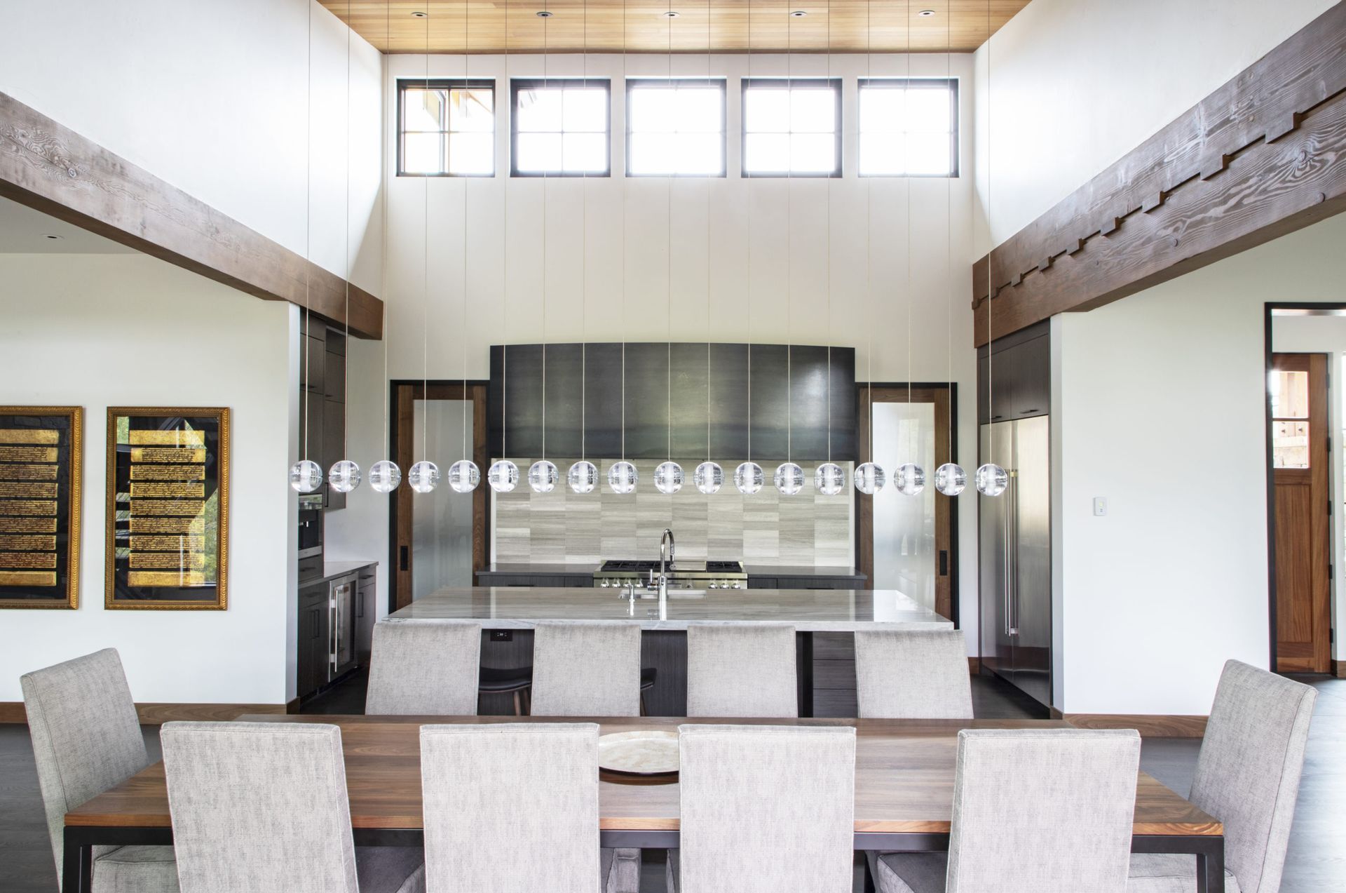 A dining room with a table and chairs and a kitchen