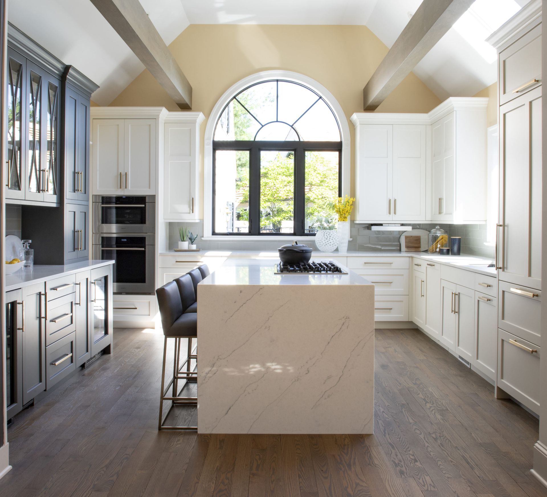 A kitchen with white cabinets and a large island in the middle