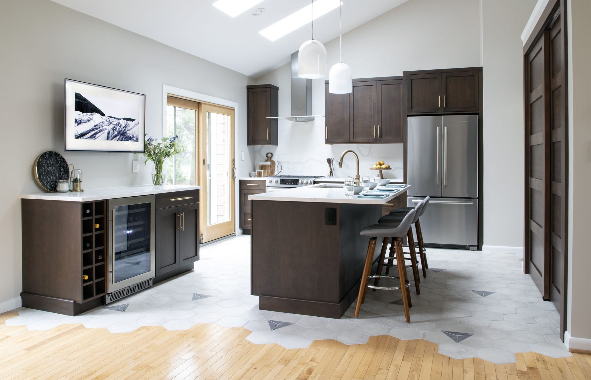 Modern kitchen with dark brown cabinets, stainless steel appliances, and island with seating.