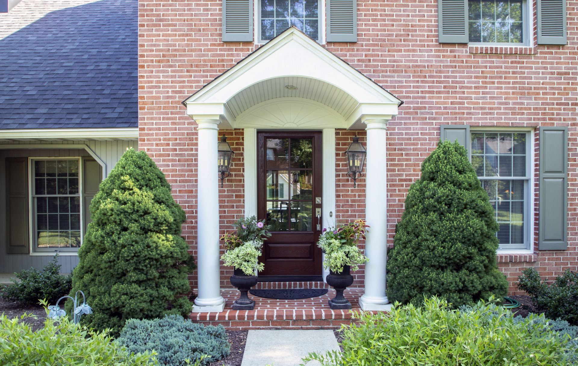 A brick house with a porch and columns