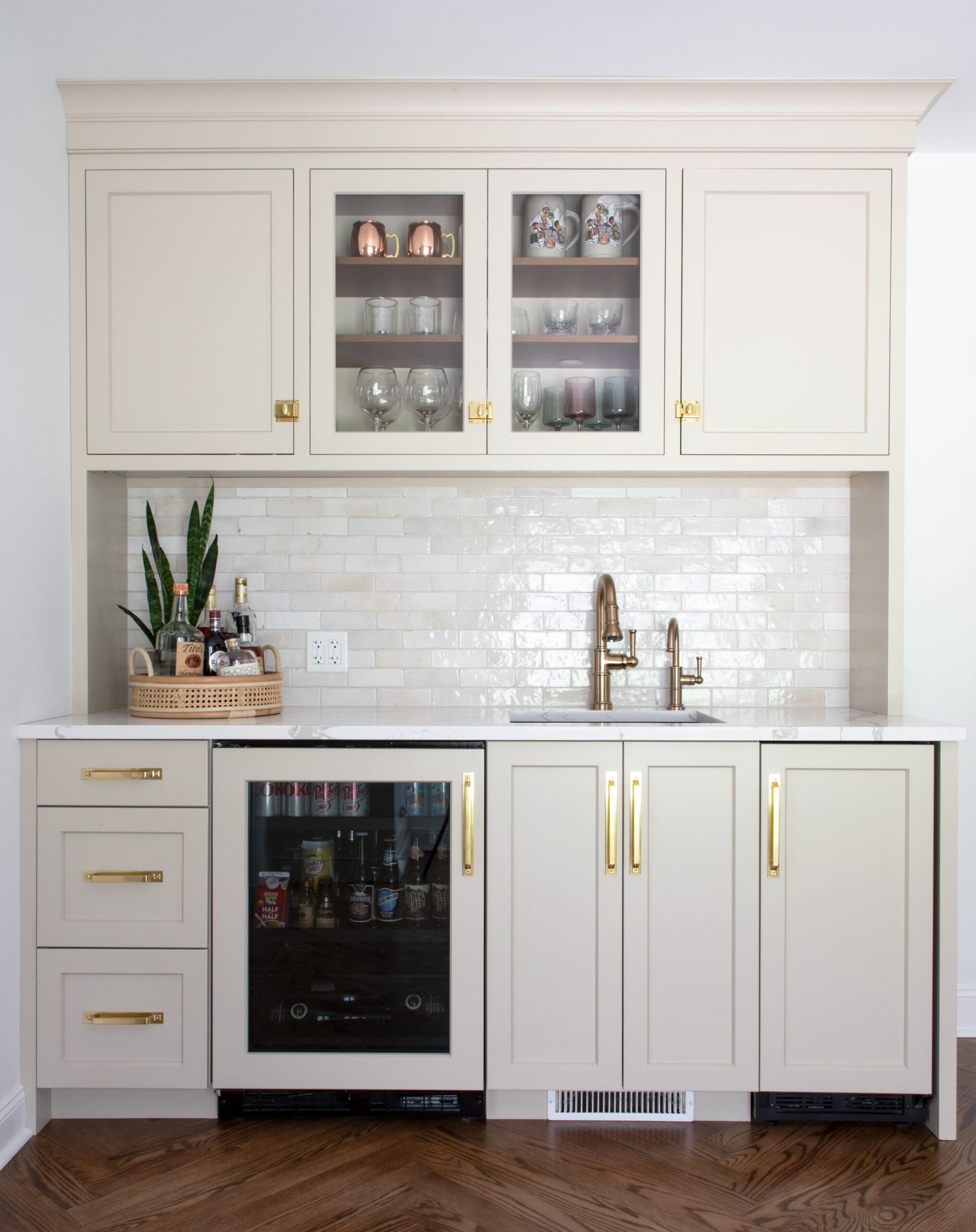 A kitchen with white cabinets , a sink , and a refrigerator.