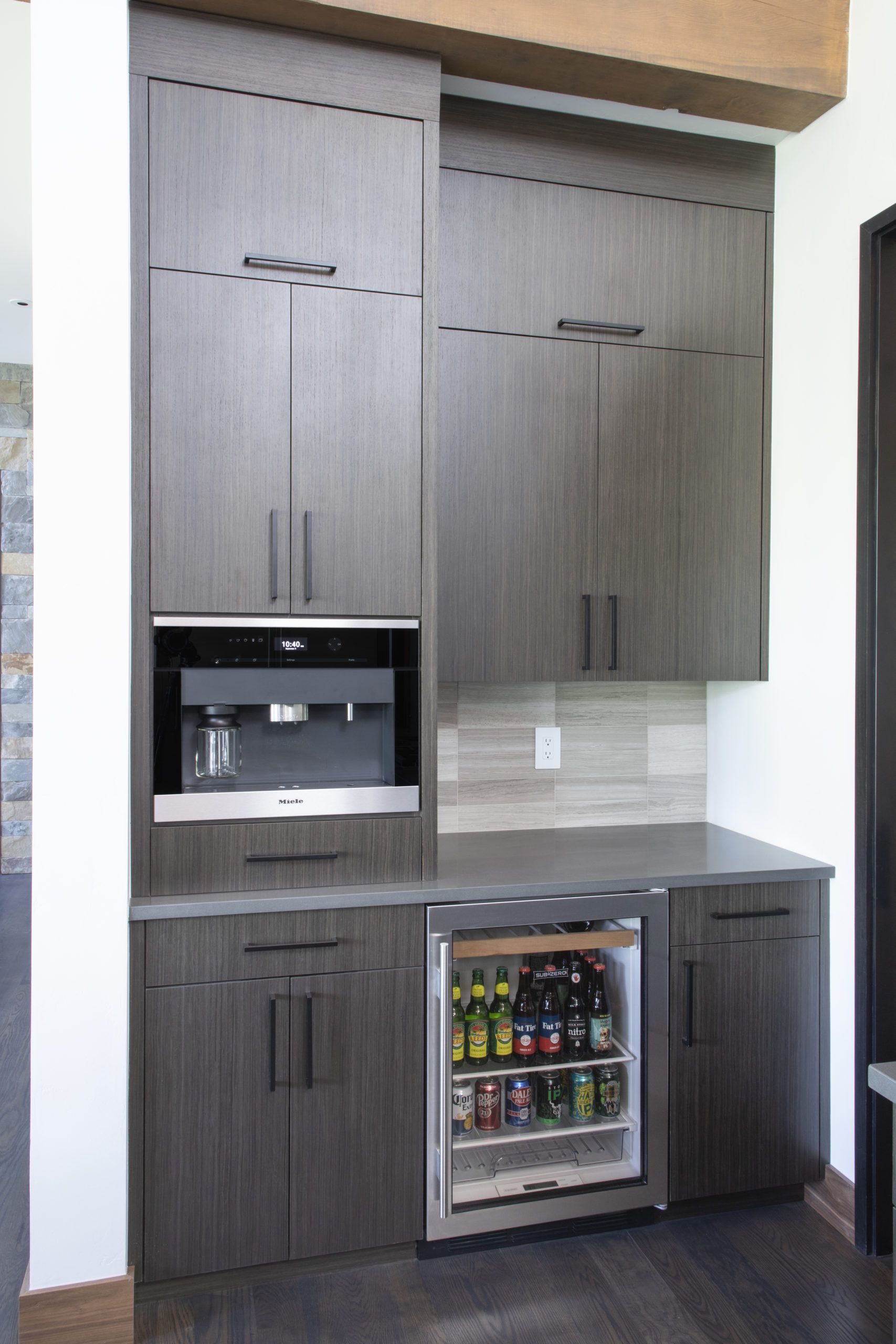 A kitchen with a refrigerator and a coffee maker