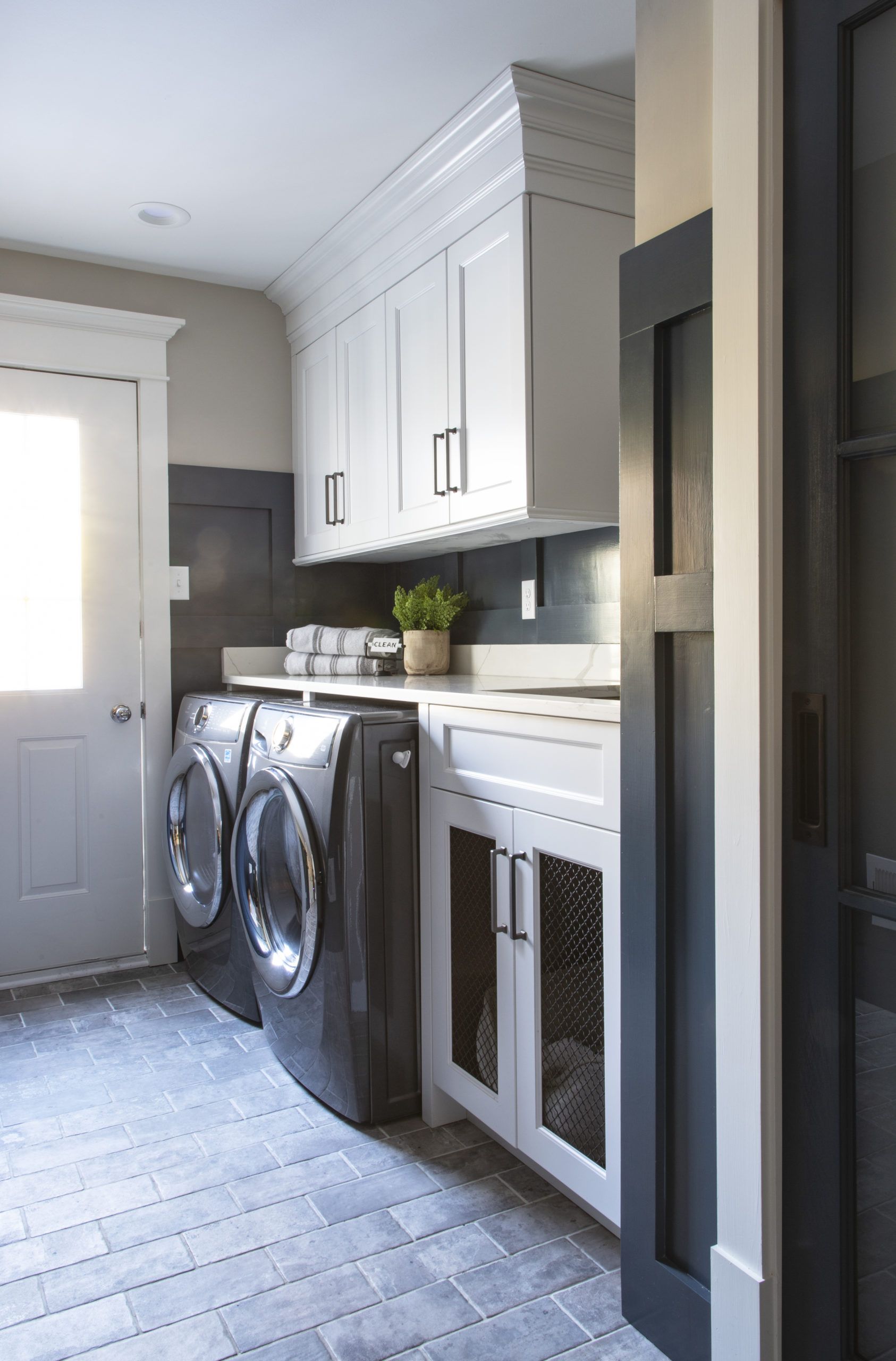 A laundry room with a washer and dryer and white cabinets.