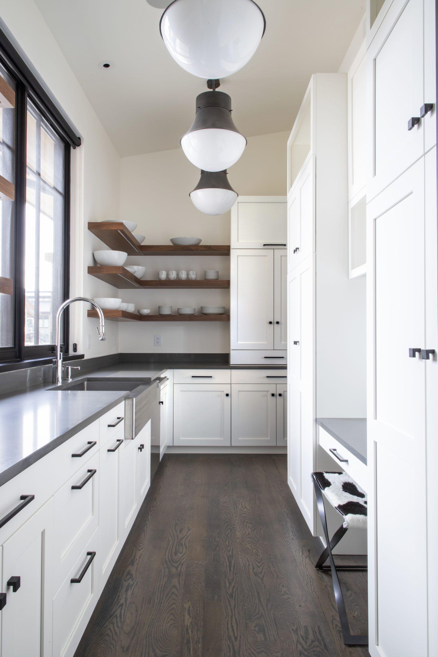 A kitchen with white cabinets and black counter tops