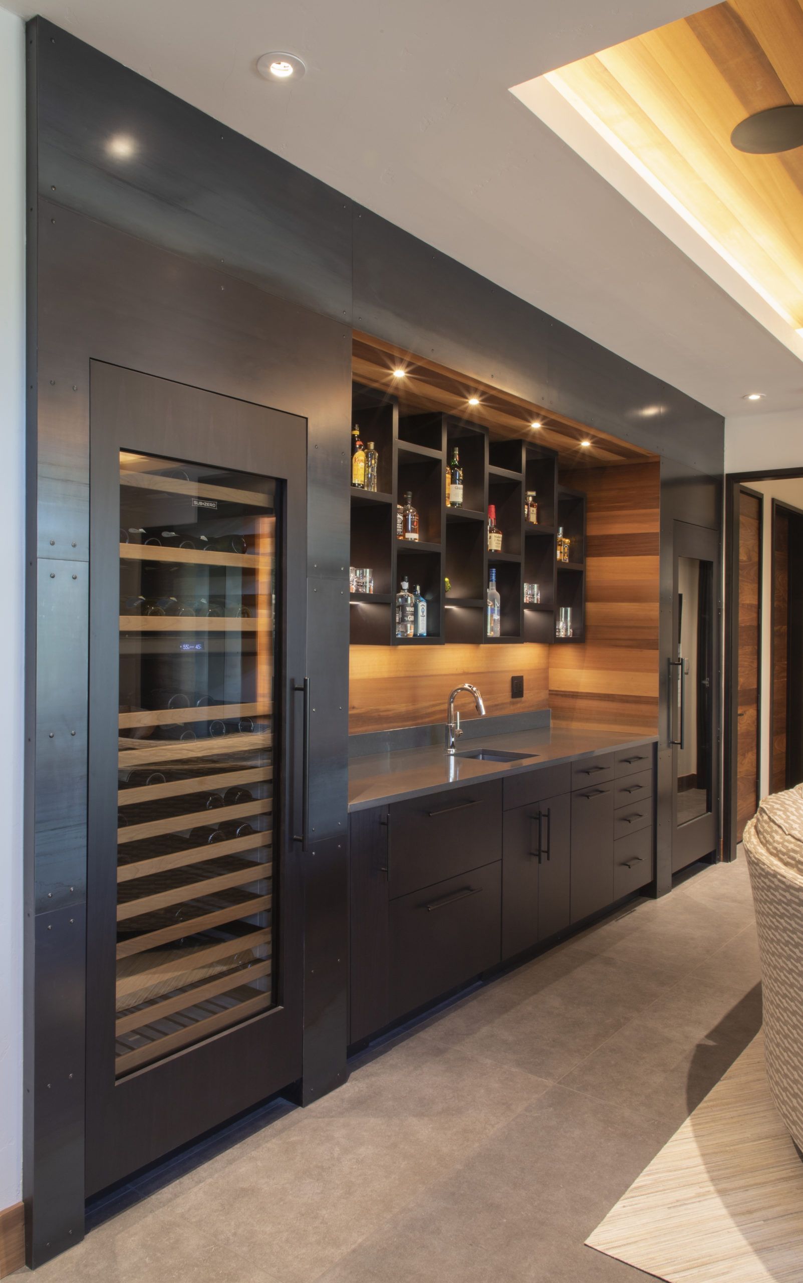 A kitchen with a wine cooler and a sink