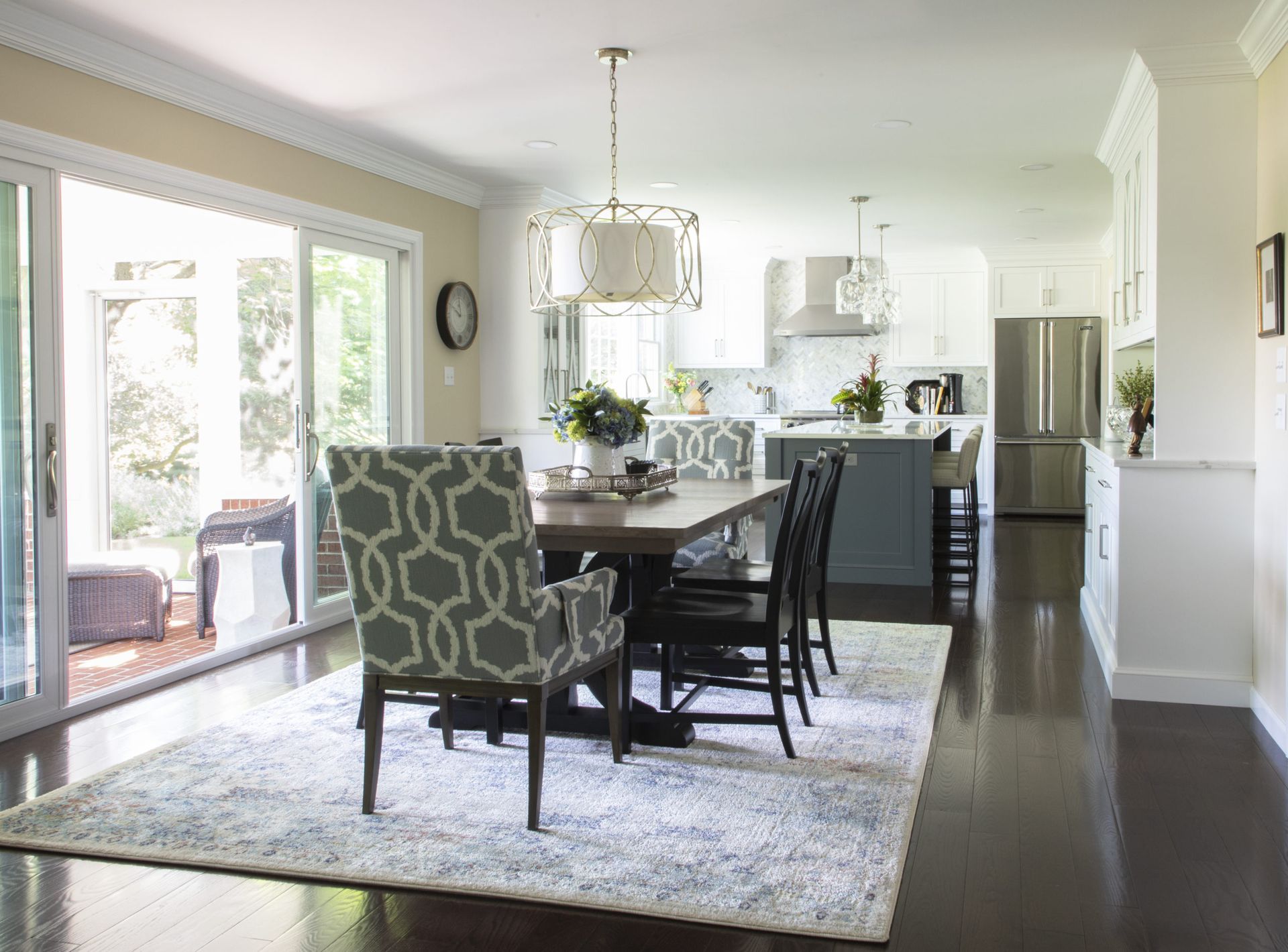 A dining room with a table and chairs and a rug.