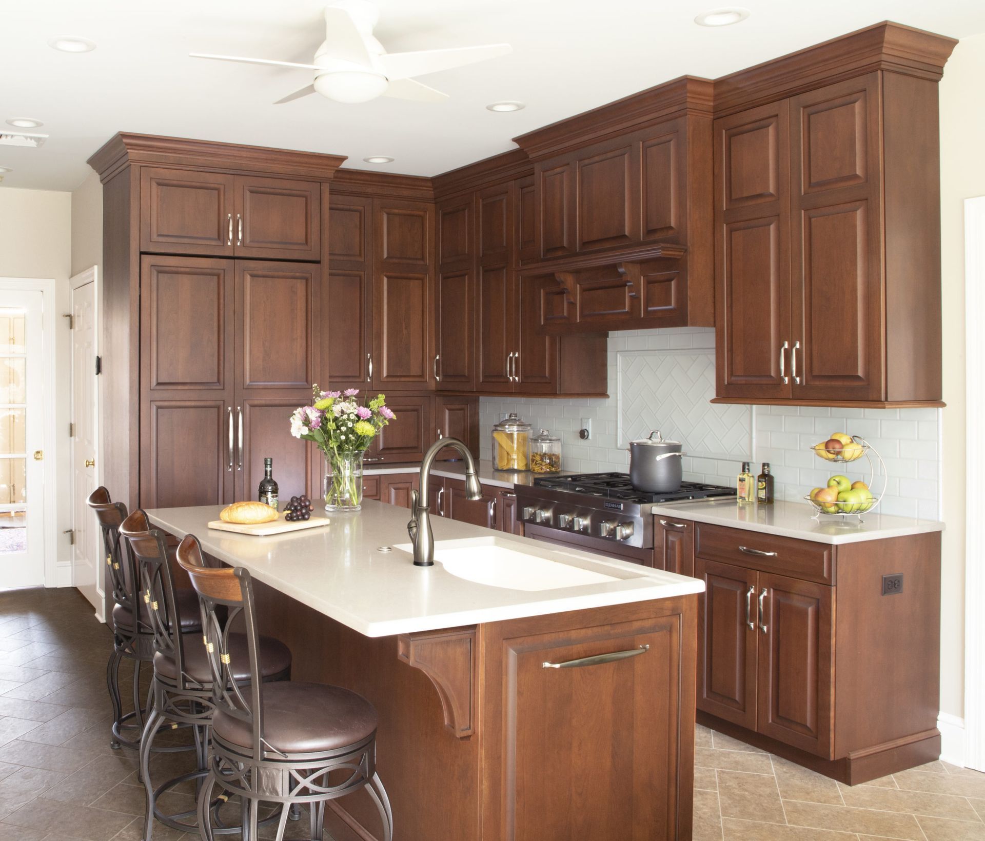 A kitchen with wooden cabinets and a large island