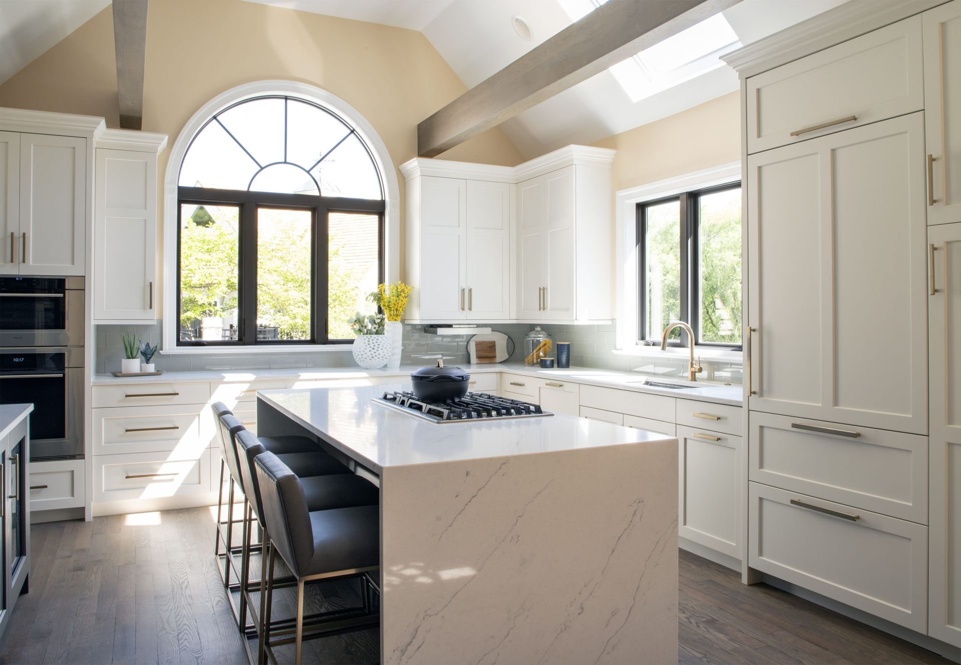 A kitchen with white cabinets and a large island in the middle.