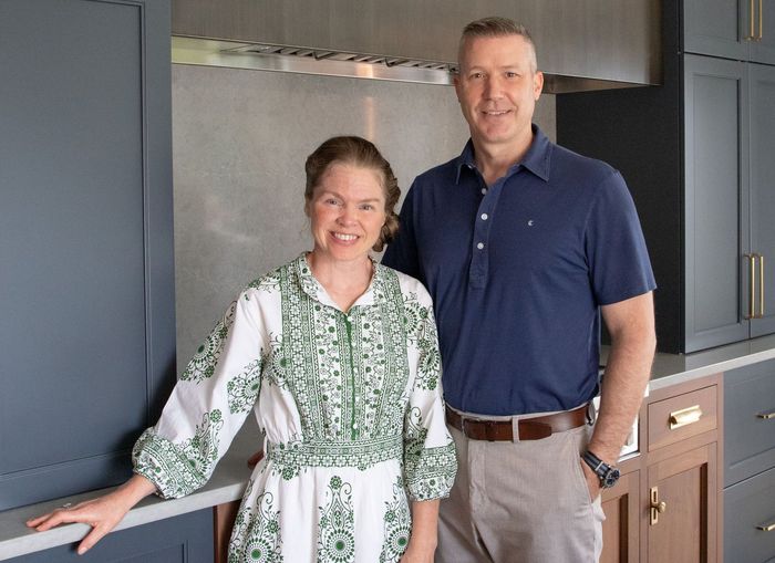 A man and a woman are standing next to each other in a kitchen.