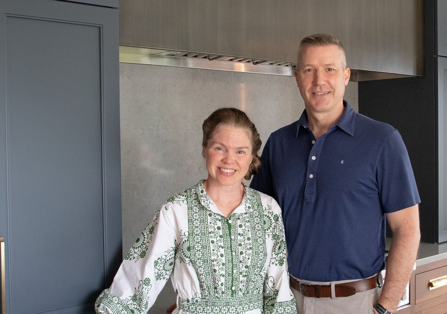 Esther and Aaron from KBE Design Build pose in a kitchen, smiling.
