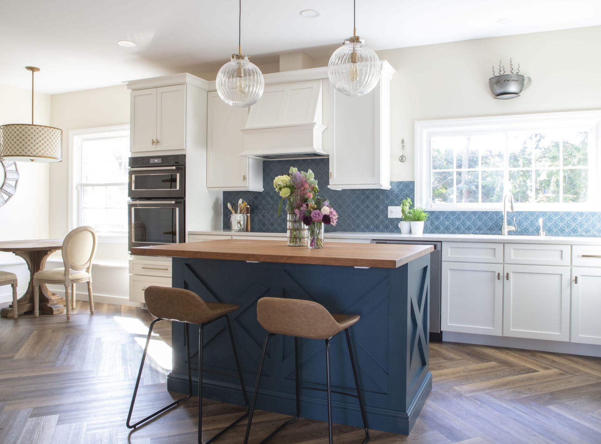 A kitchen with a blue island and white cabinets