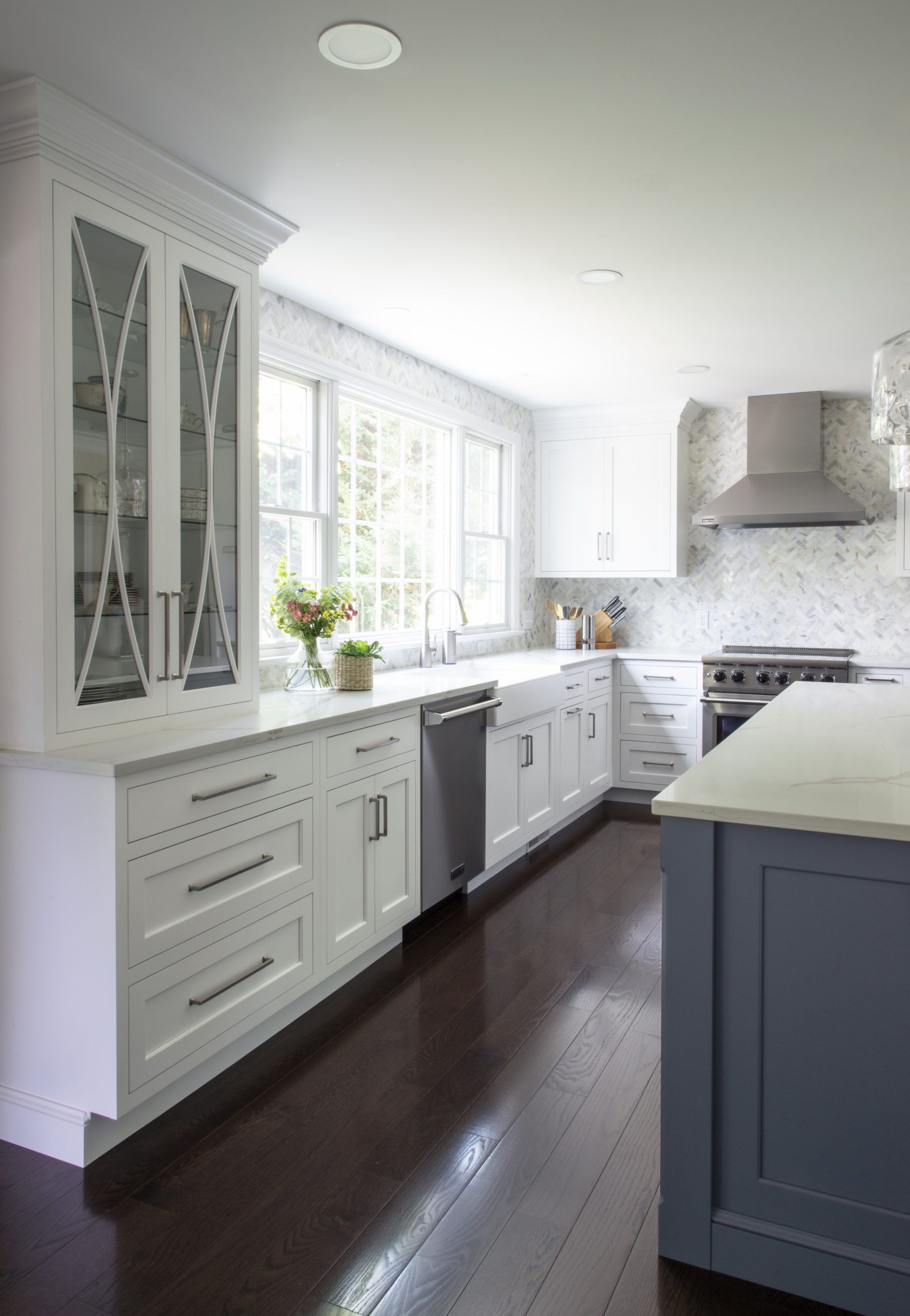 A kitchen with white cabinets and a blue island