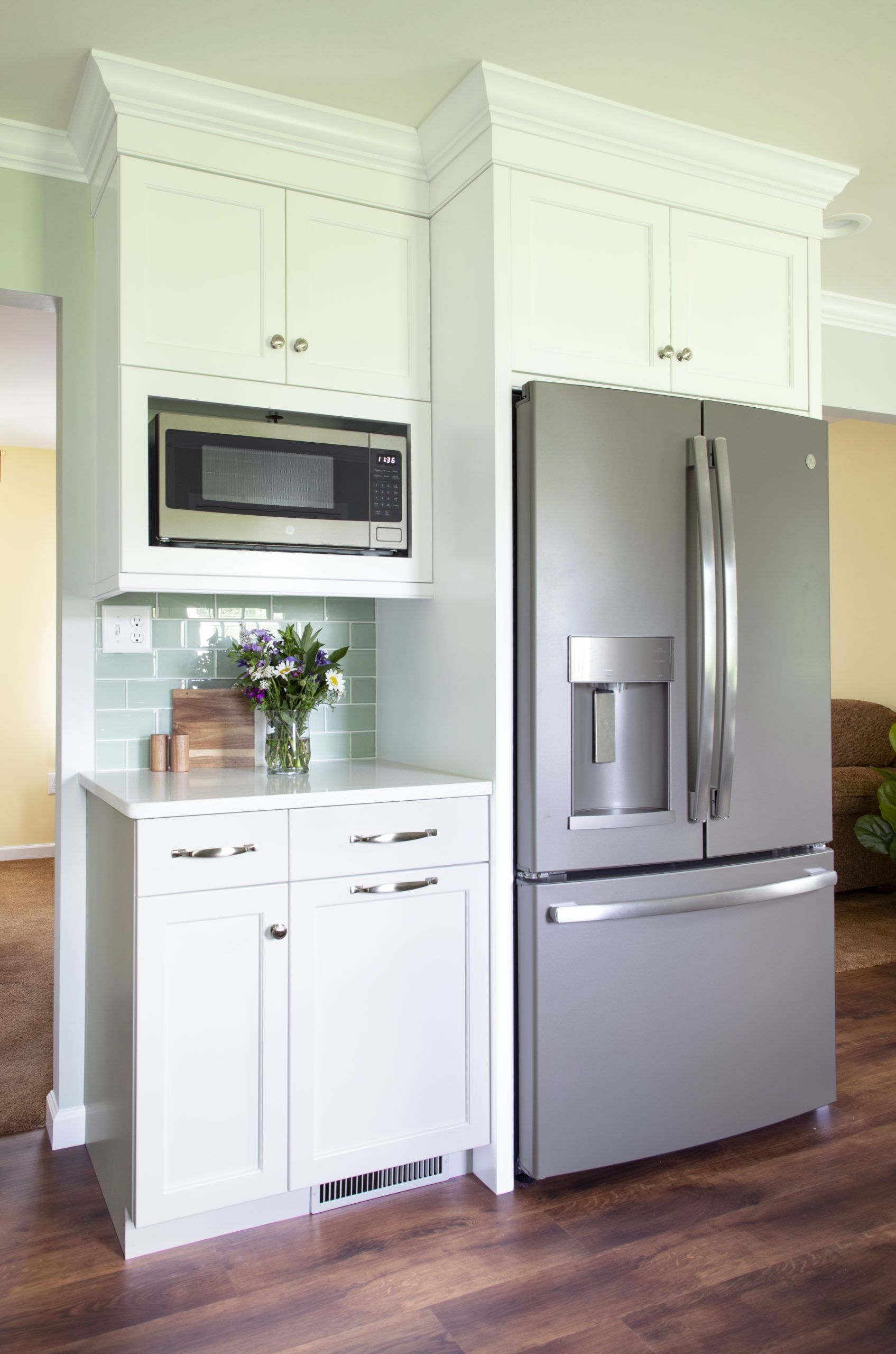 A kitchen with a stainless steel refrigerator and a microwave.