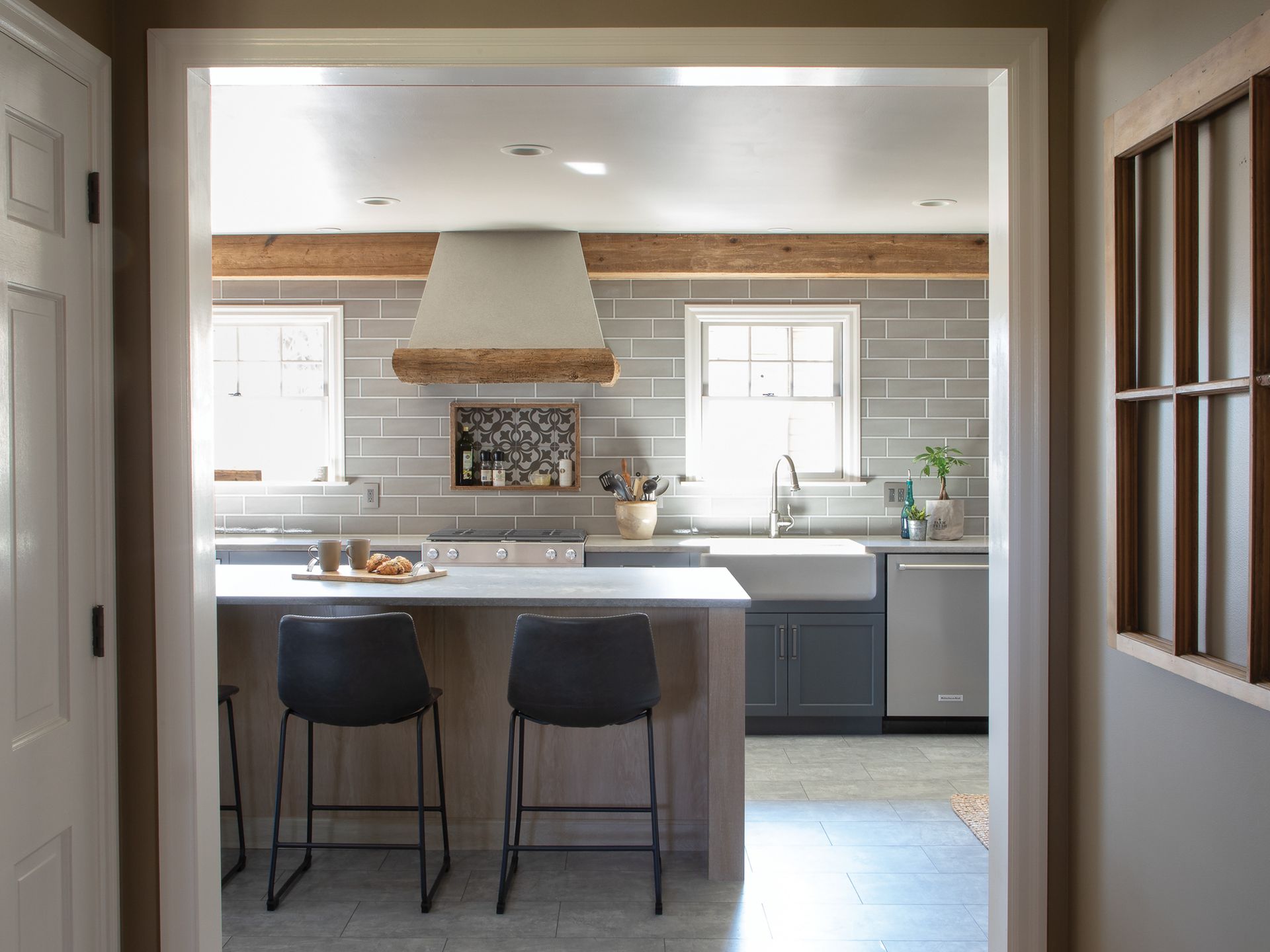 A kitchen with a stove top oven , sink , and stools.