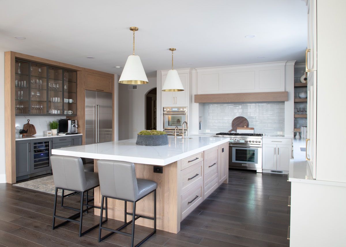 A kitchen with a large island in the middle and stools.