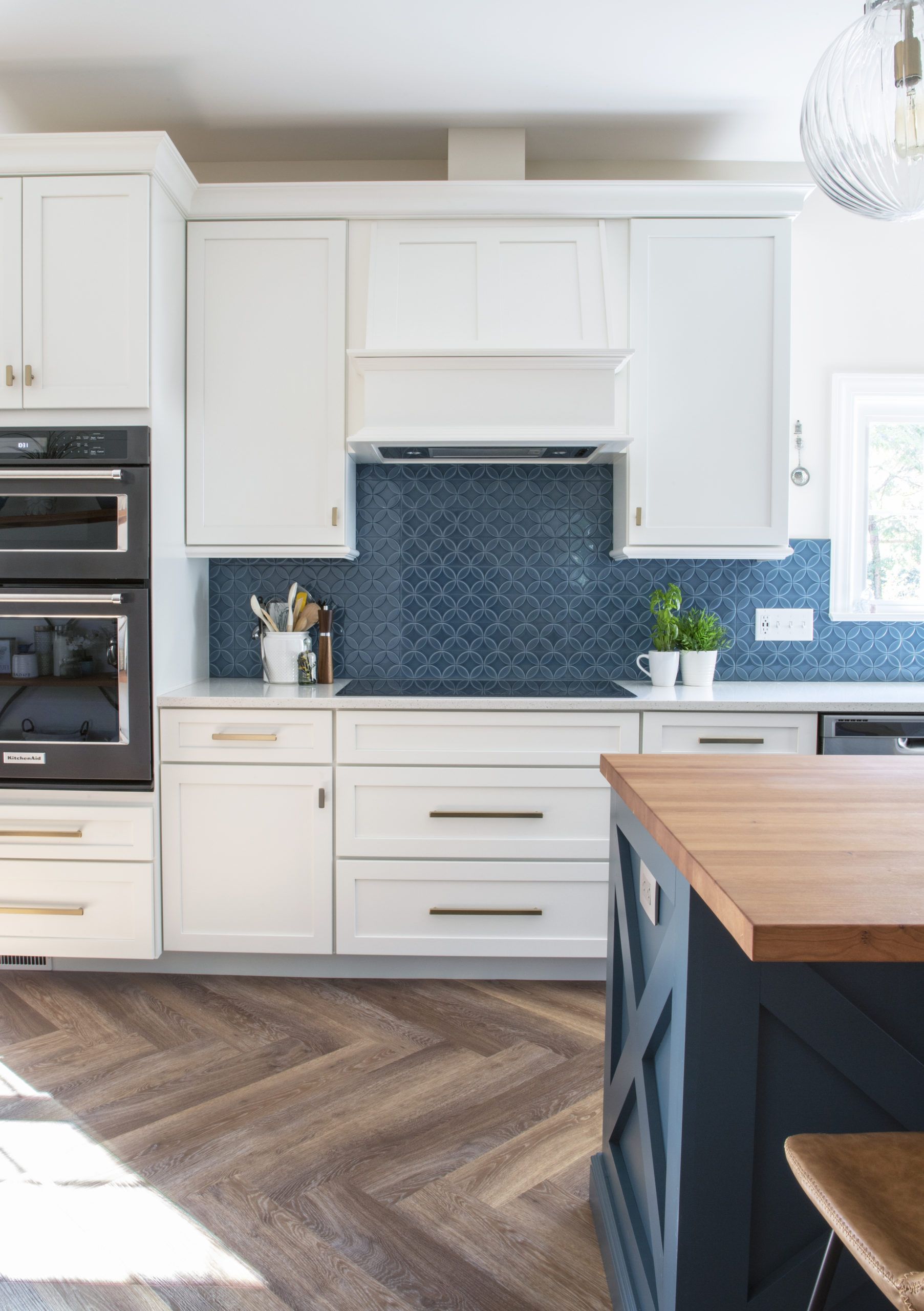 A kitchen with white cabinets and a blue island