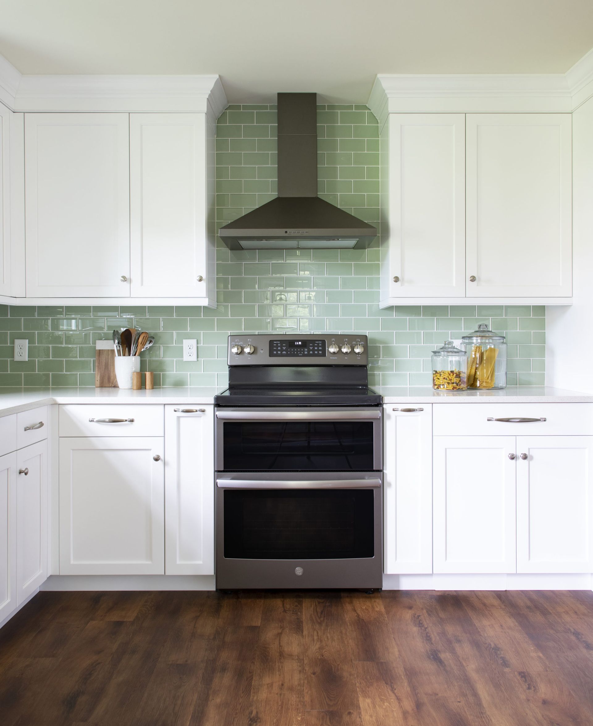 A kitchen with white cabinets and a stove top oven