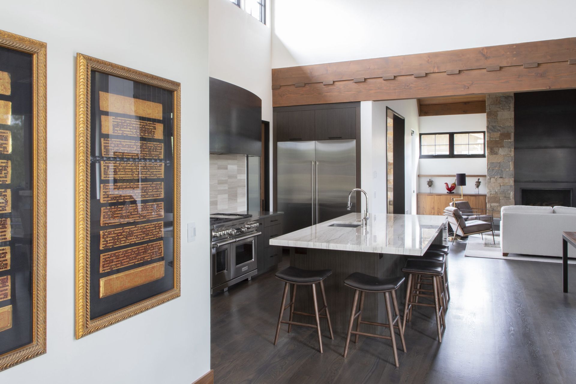 A kitchen with a large island and stools in it