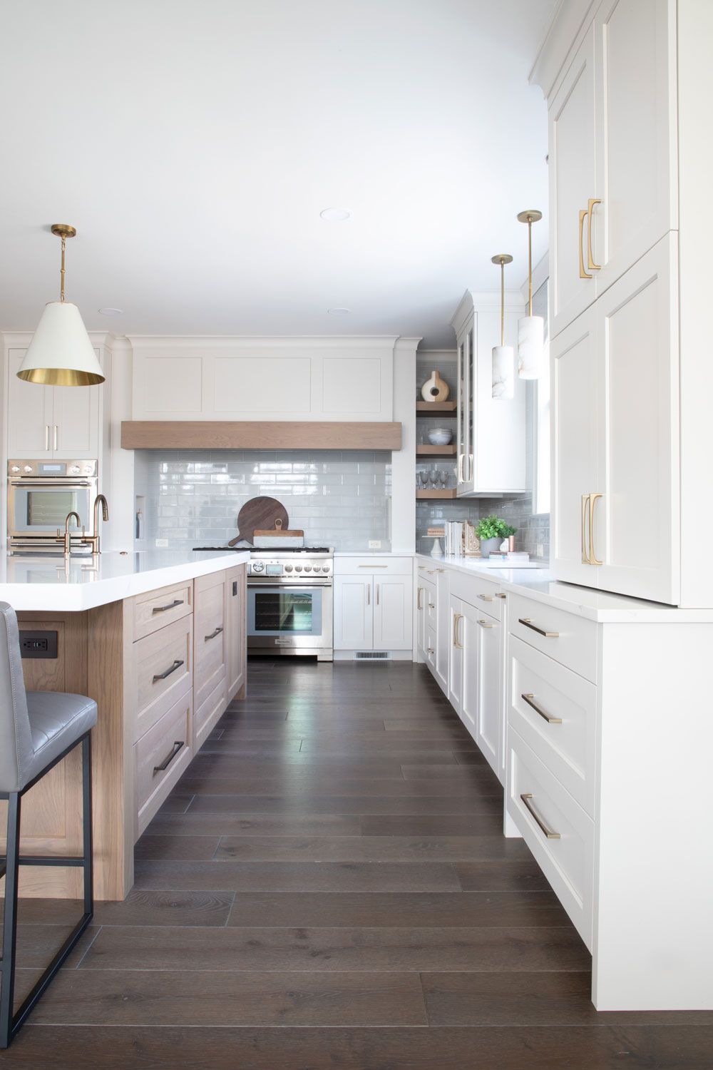 A kitchen with white cabinets , wooden floors , and stainless steel appliances.
