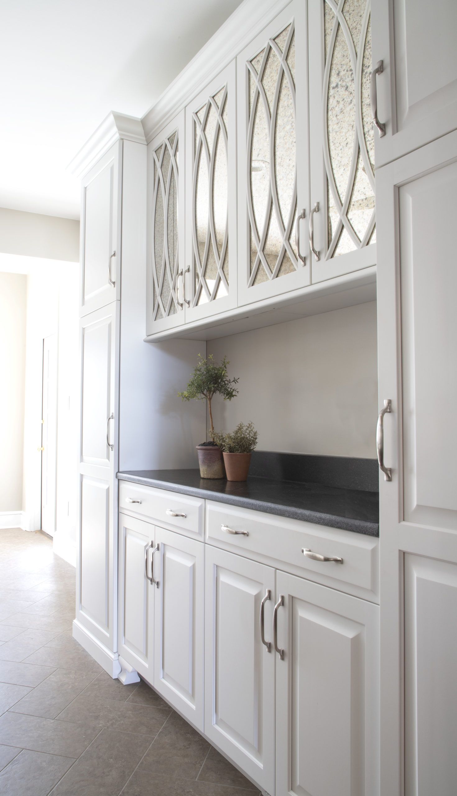 A kitchen with white cabinets and black counter tops