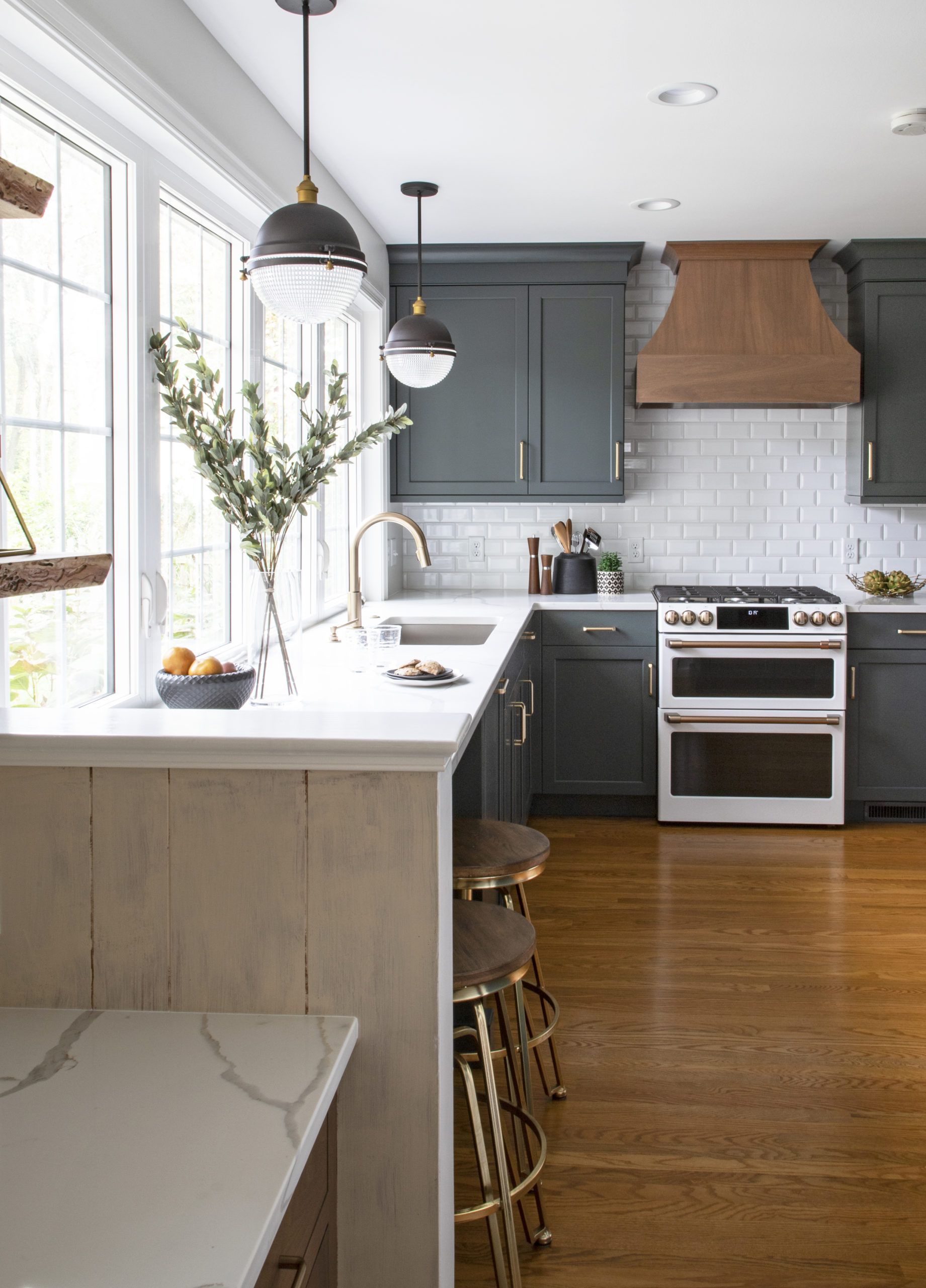 A kitchen with a stove , sink , and stools.