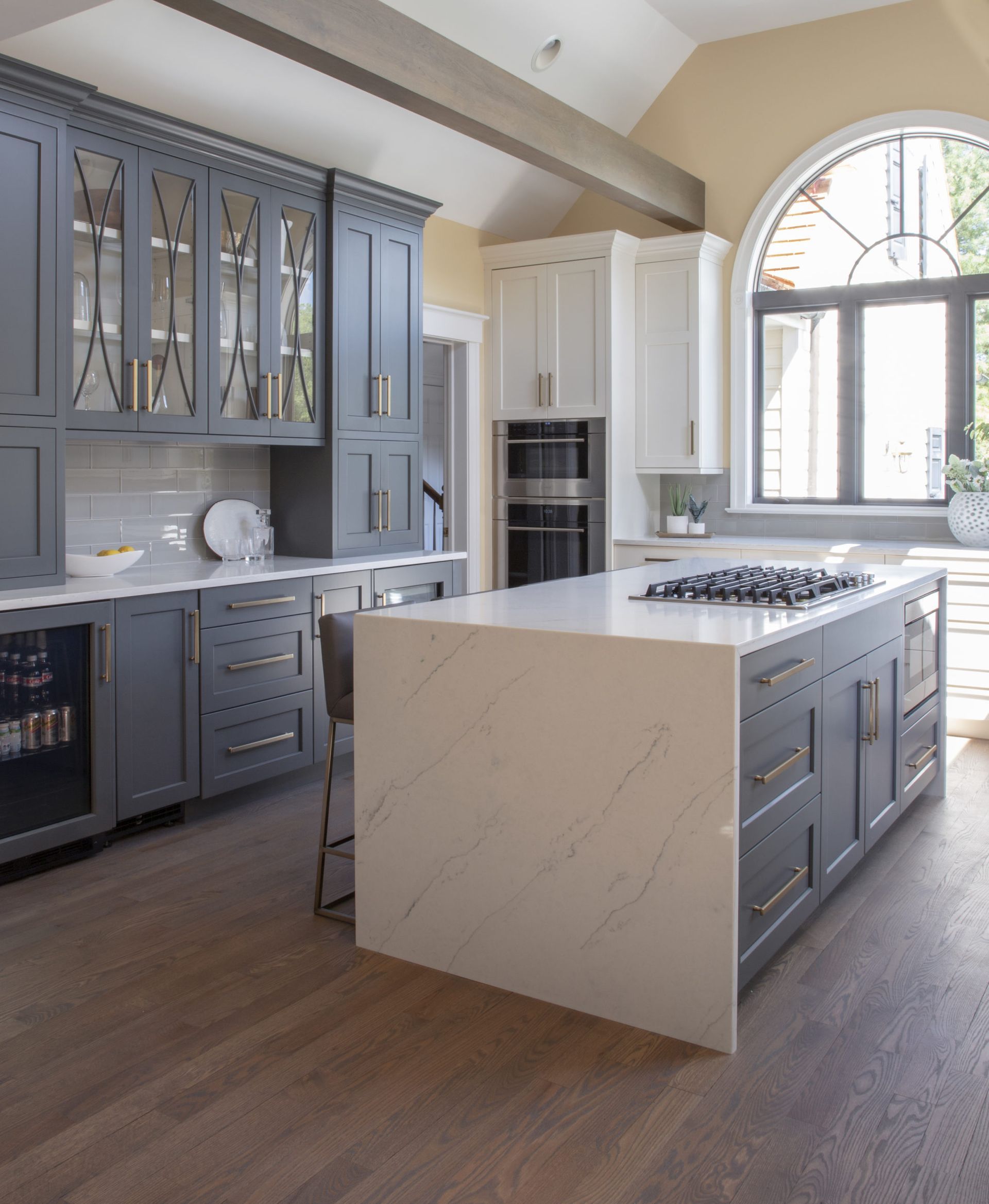 A kitchen with gray cabinets and white counter tops