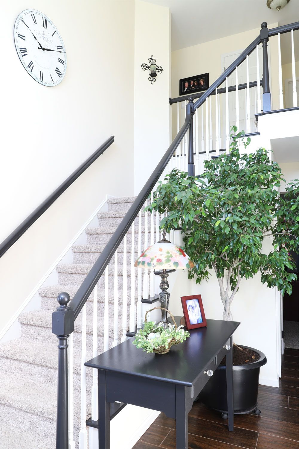A clock hangs above a staircase in a house