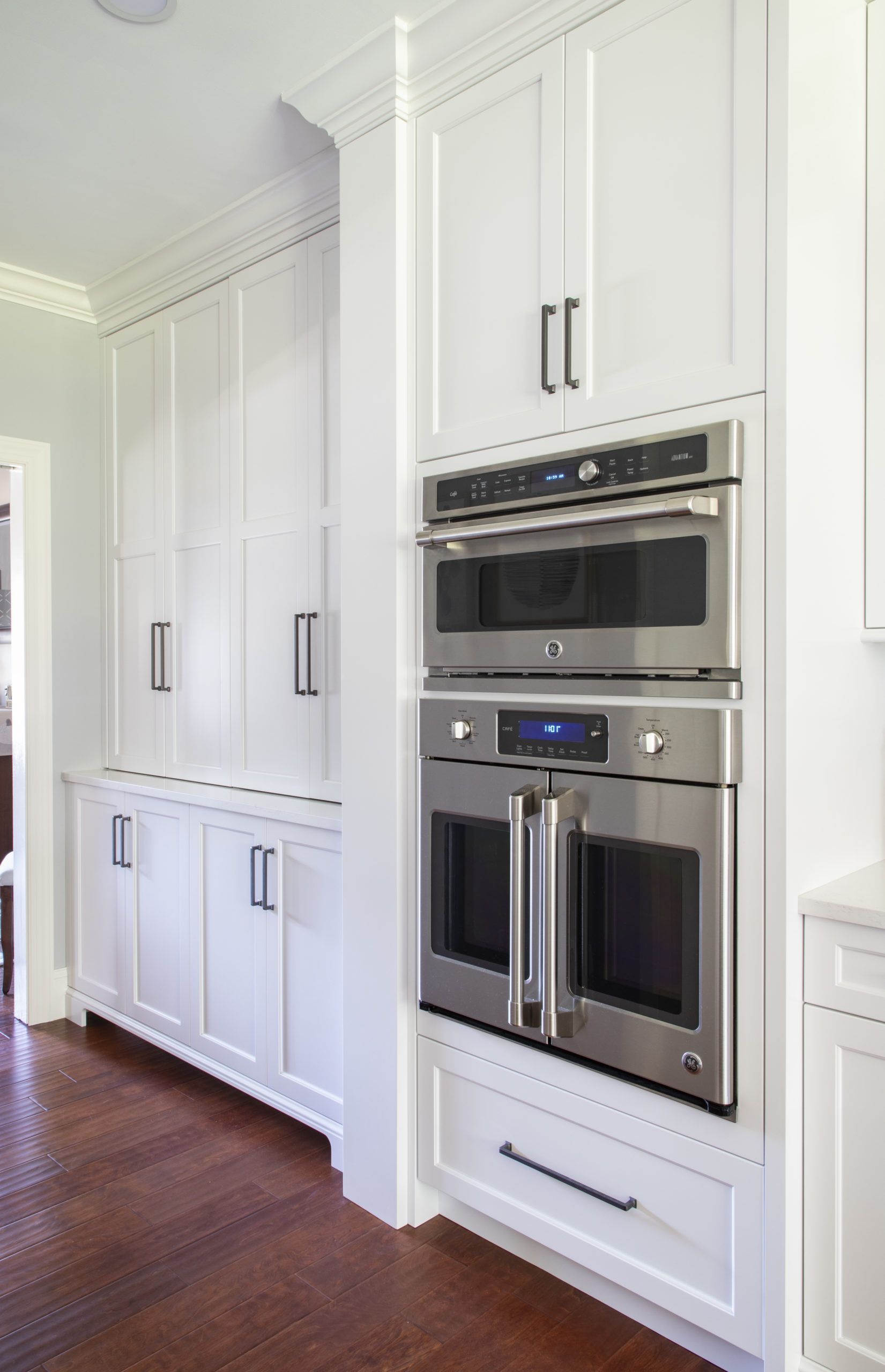 A kitchen with white cabinets and stainless steel appliances